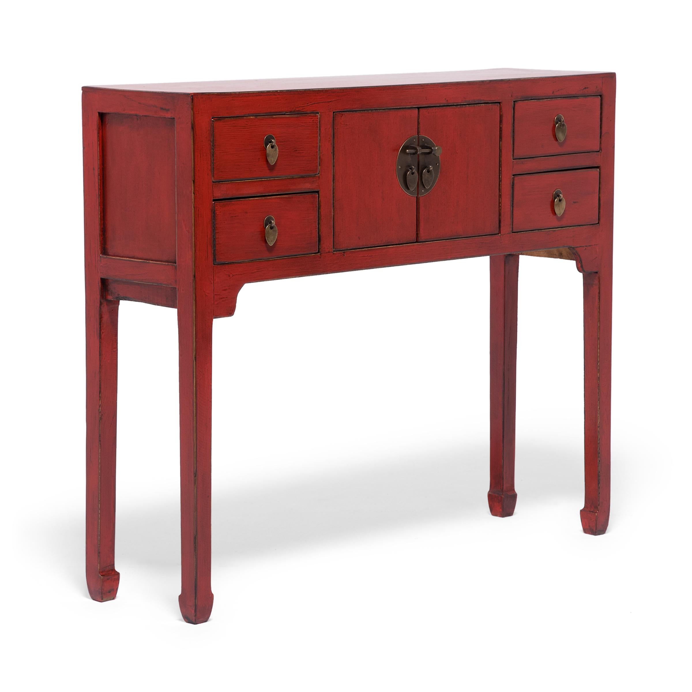 This red lacquer altar coffer keeps with the style of Ming-dynasty furniture through its clean lines and minimal ornamentation. The slim legs and delicate hoof feet bring the eye upwards the squared frame and contribute to the effortless simplicity