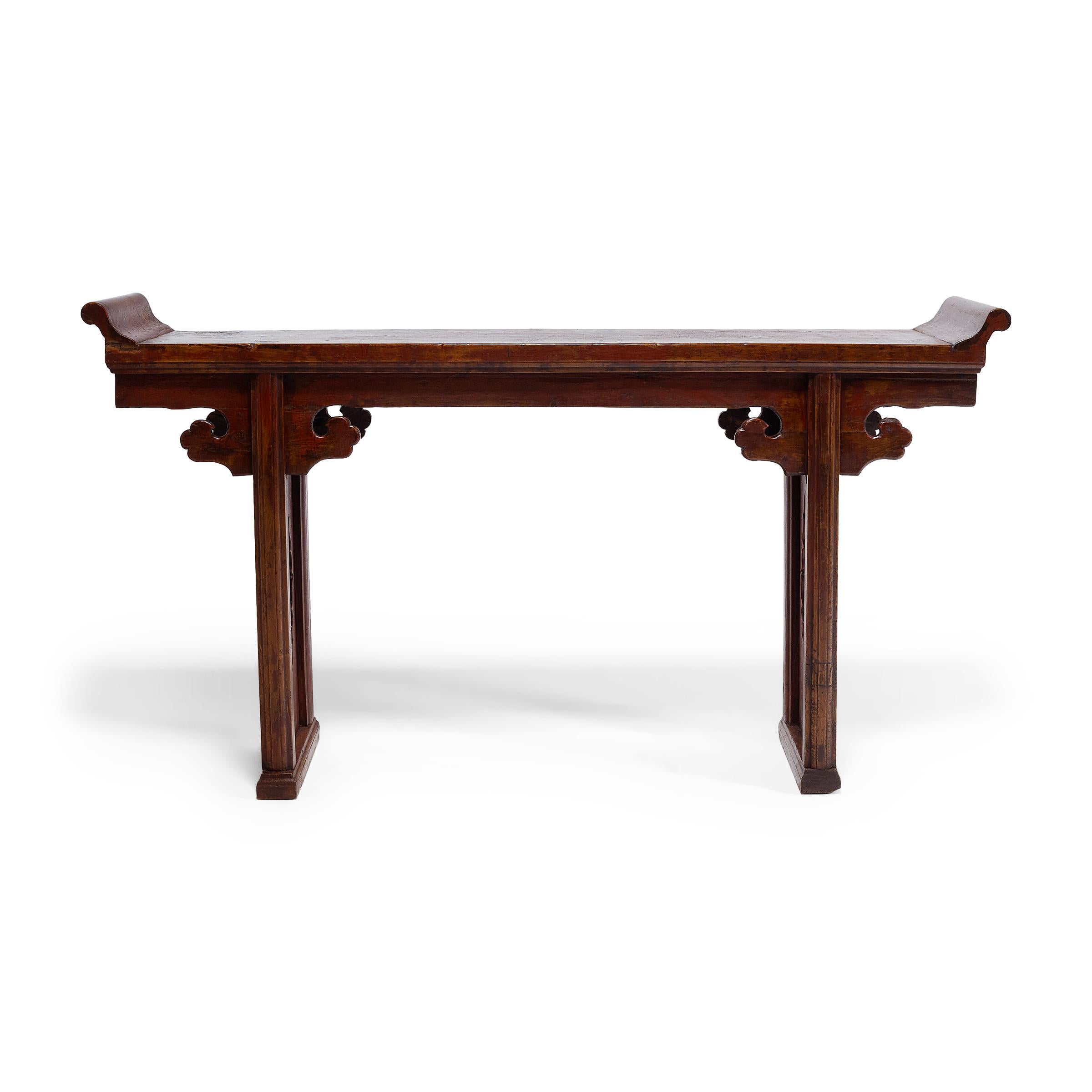 In a traditional Chinese home, a long narrow table with everted flanges is placed in the main hall and set with beautiful objects such as instruments, flowers, or porcelains. Often referred to as altar tables, these slender tables are also used as a
