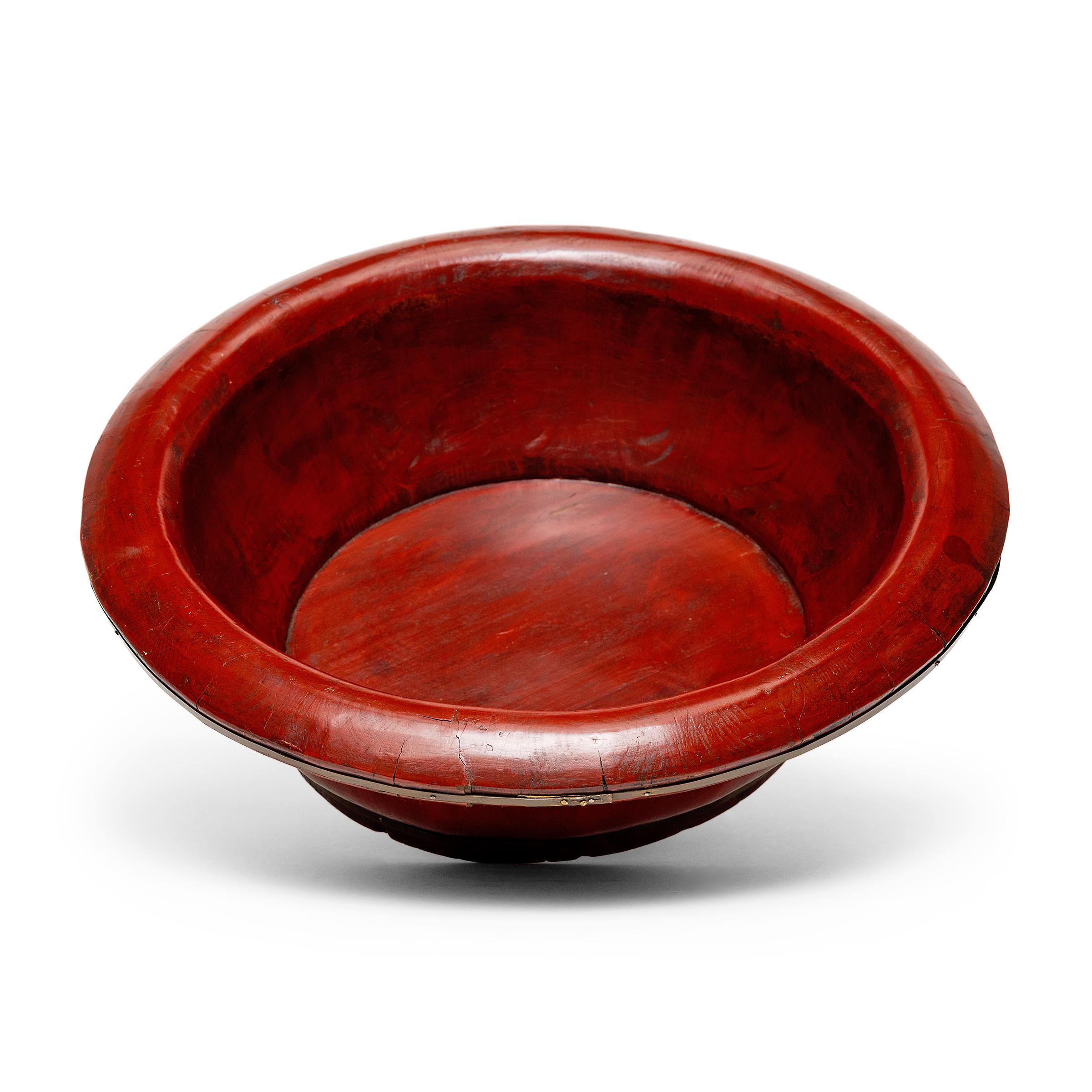 This shallow lacquered bowl dates to the late 19th century and was originally used as a wash basin for fruits and vegetables. The round vessel is crafted like a barrel, with slatted elmwood sides banded with brass strips, a method used for all kinds