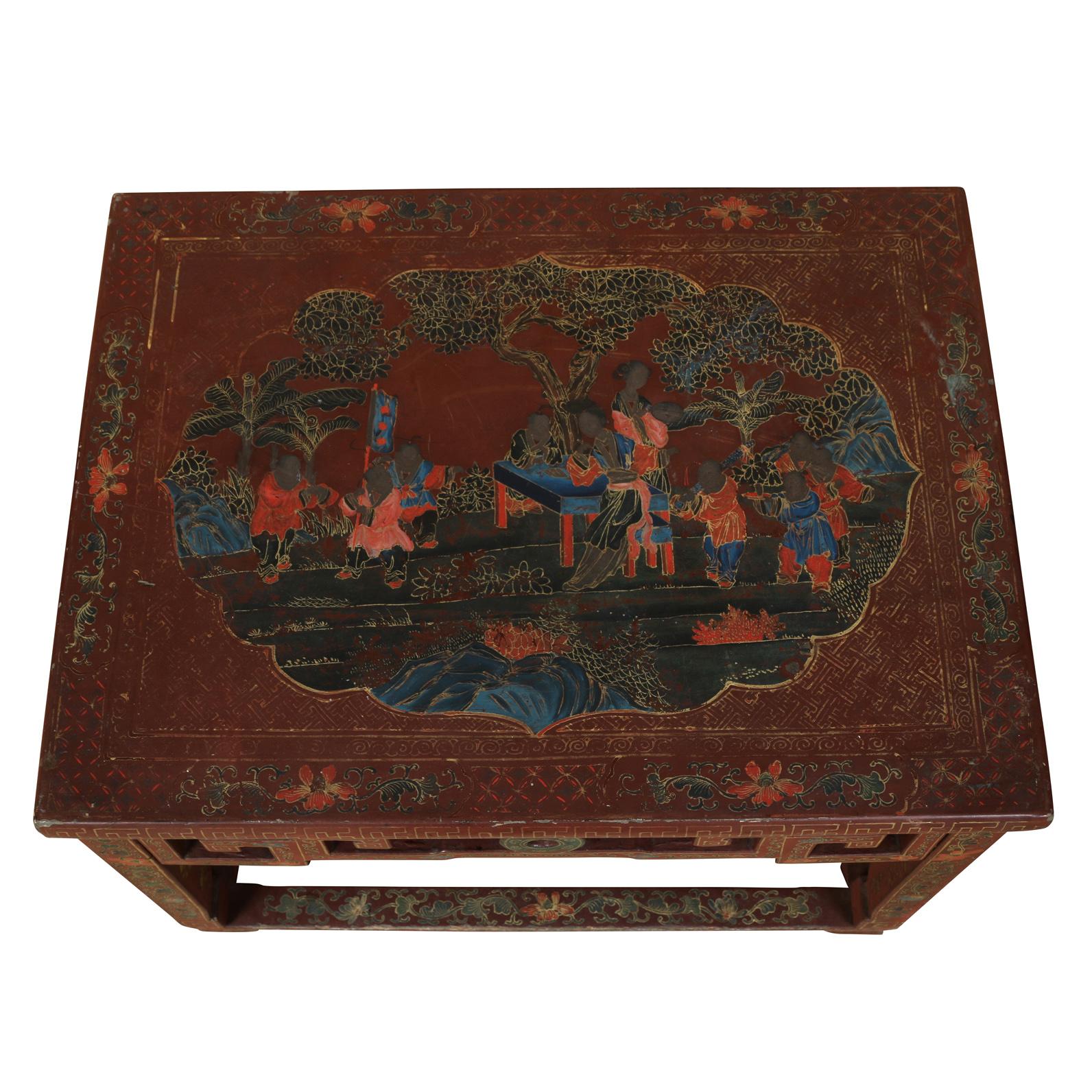 A Chinese red lacquered table with intricate gilt decoration depicturing flora, figures and geometric design and fretwork to sides.