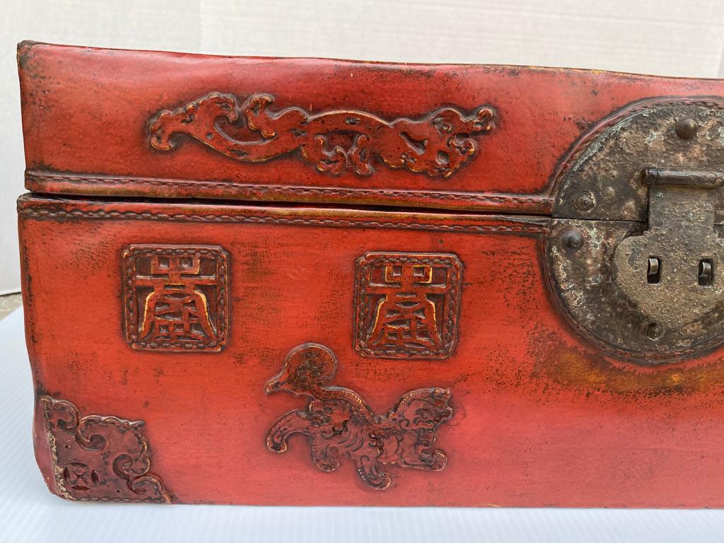 This Chinese leather trunk is red lacquered having 