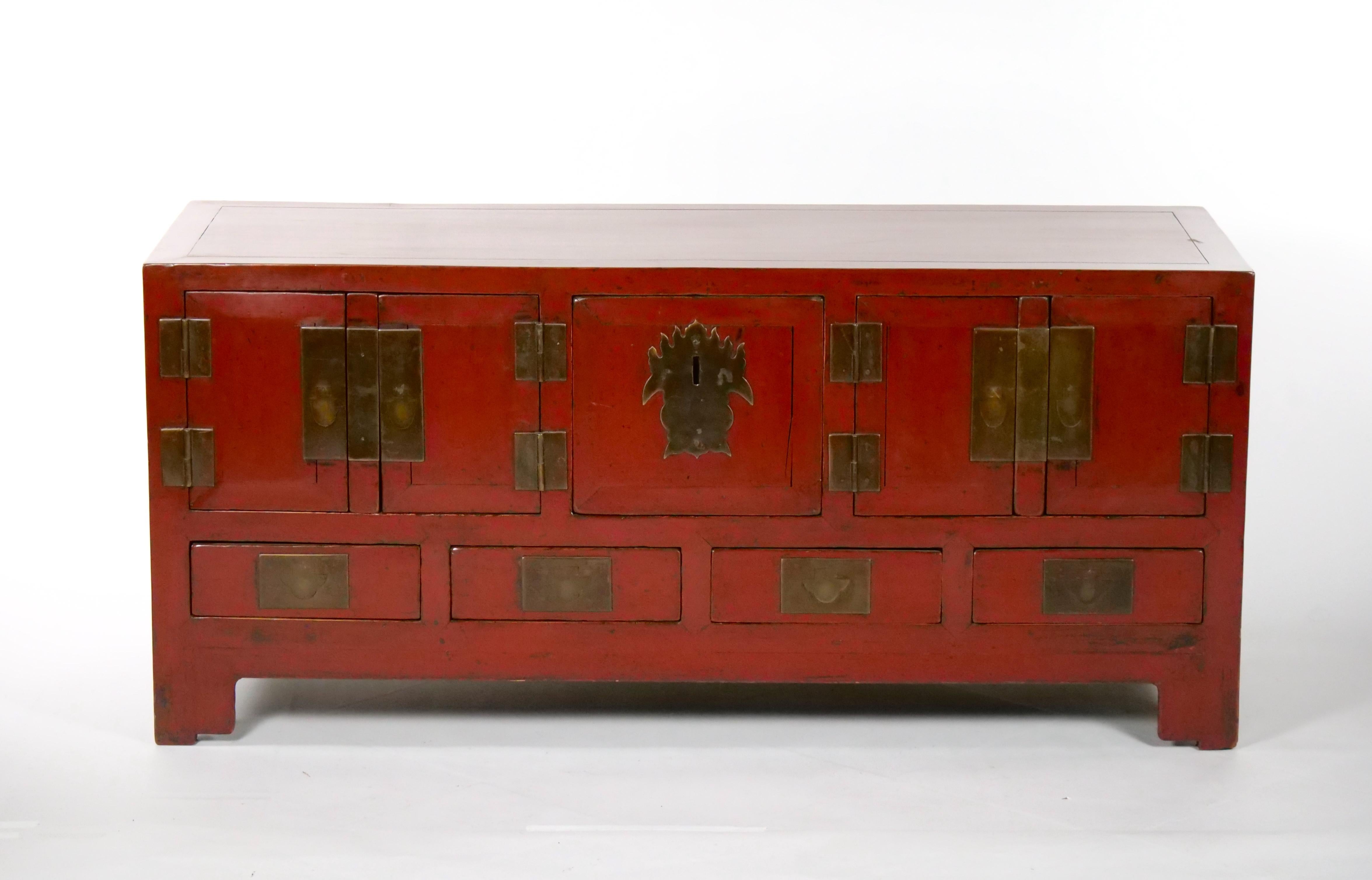 Beautiful red-lacquered Chinese sideboard / low center table was made from reclaimed pine wood with traditional nail-less joinery. The red lacquer has been enhanced with a sophisticated French polish finish and hardware decoration. This piece is