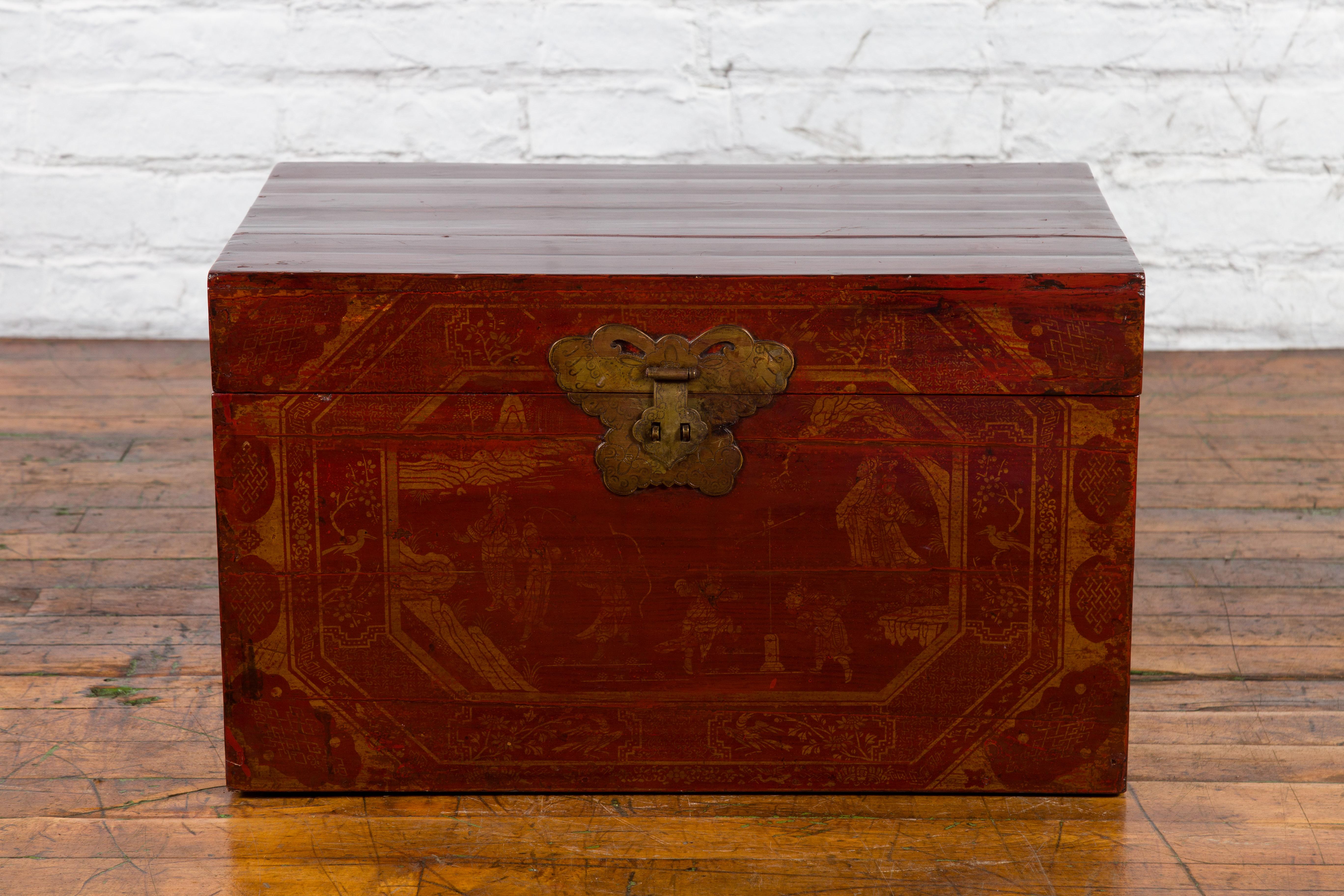 An antique Chinese red lacquered trunk from the early 20th century, with court scenes, foliage and birds. Created in China during the early years of the 20th century, this red lacquered trunk features a rectangular lid opening thanks to a brass