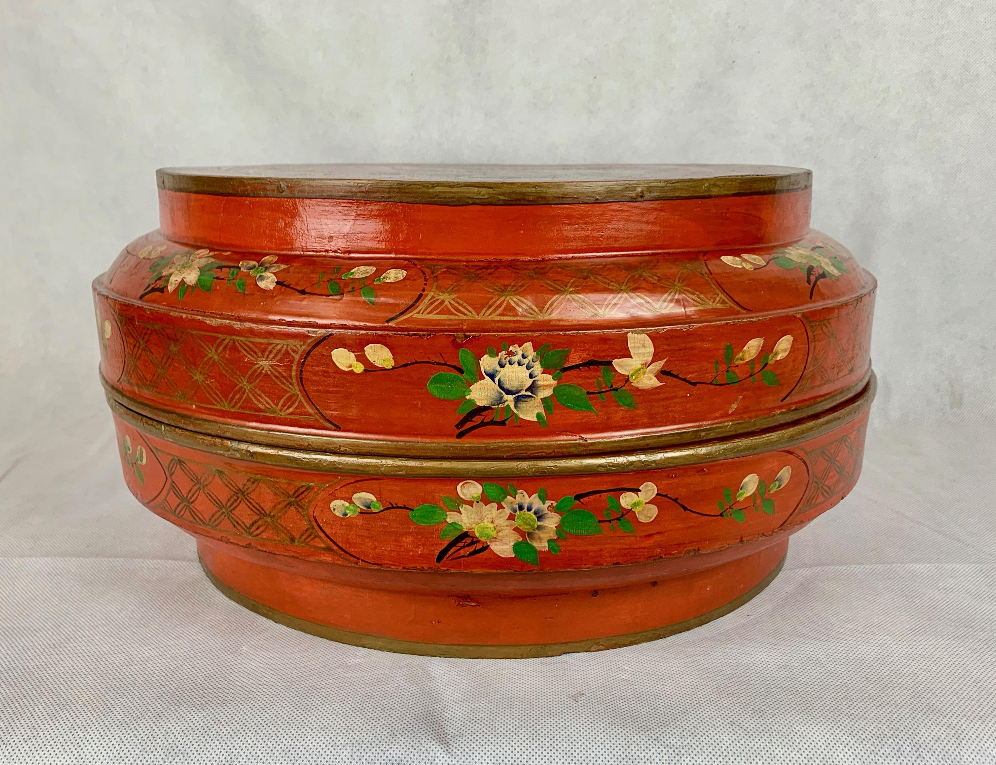 Chinese red lacquer two part wedding box. Entirely hand decorated with a bird and flowers on top and flowers and vines along the side.  The interior is painted a deep apple green along with two Chinese character marks.
Diameter-15.5