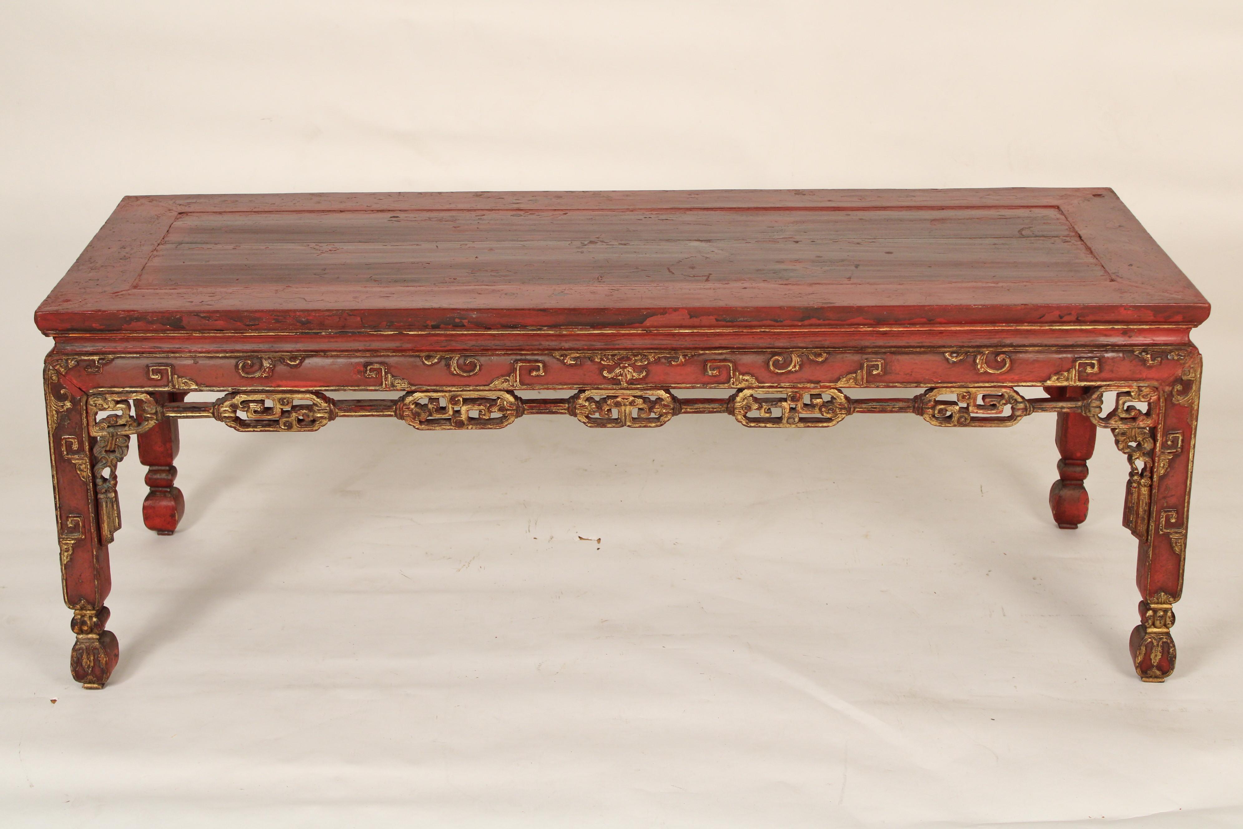 Chinese red painted coffee table with gilt highlights, circa 1930's. With a slightly over hanging rectangular top a frieze with gilt highlights, resting on square legs with gilt decoration.