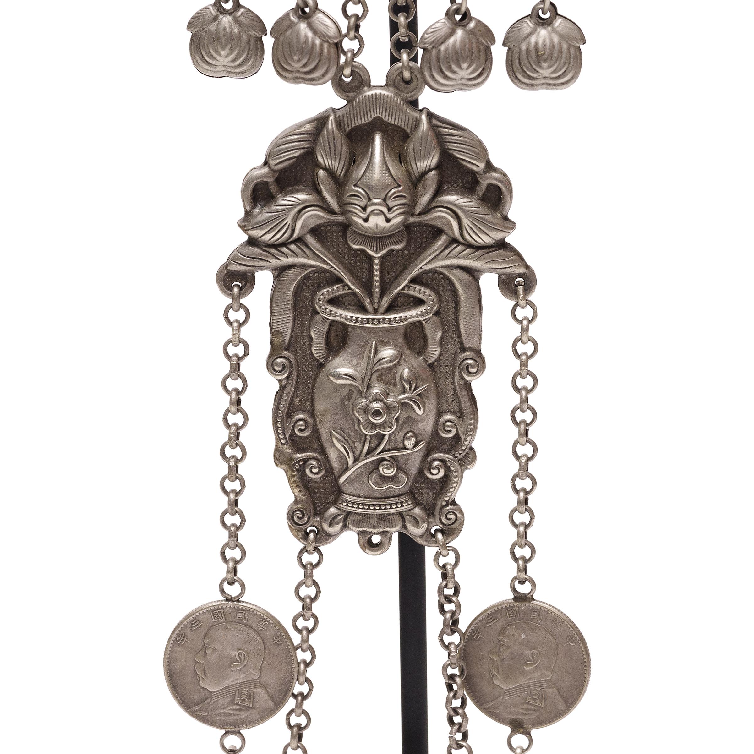 Esta elaborada cadena de colgantes y herramientas repoussé es un kit de aseo tradicional chino, intrincadamente trabajado en aleación de plata con un detalle fantástico. Al igual que una chatelaine victoriana, un set de aseo como éste se colgaba de
