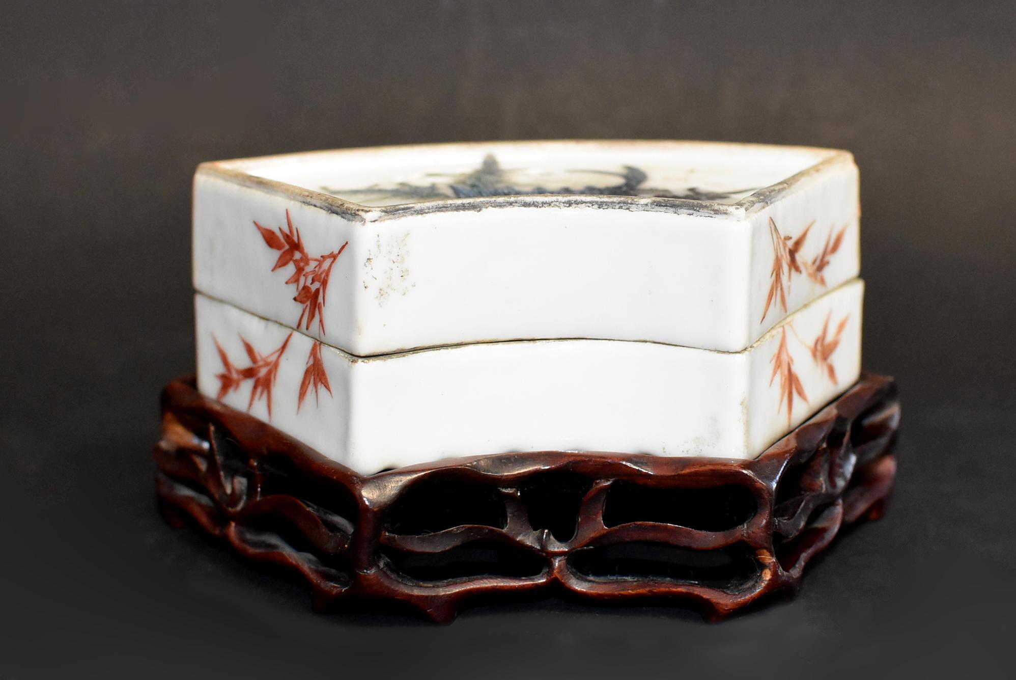 A beautiful hand painted porcelain box featuring blue koi fish and mountain scene on each side. The double sided, fan shaped box has a rippled finish on one side, and smooth on the other. Bamboos painted in vermilion decorate the sides. Beautiful