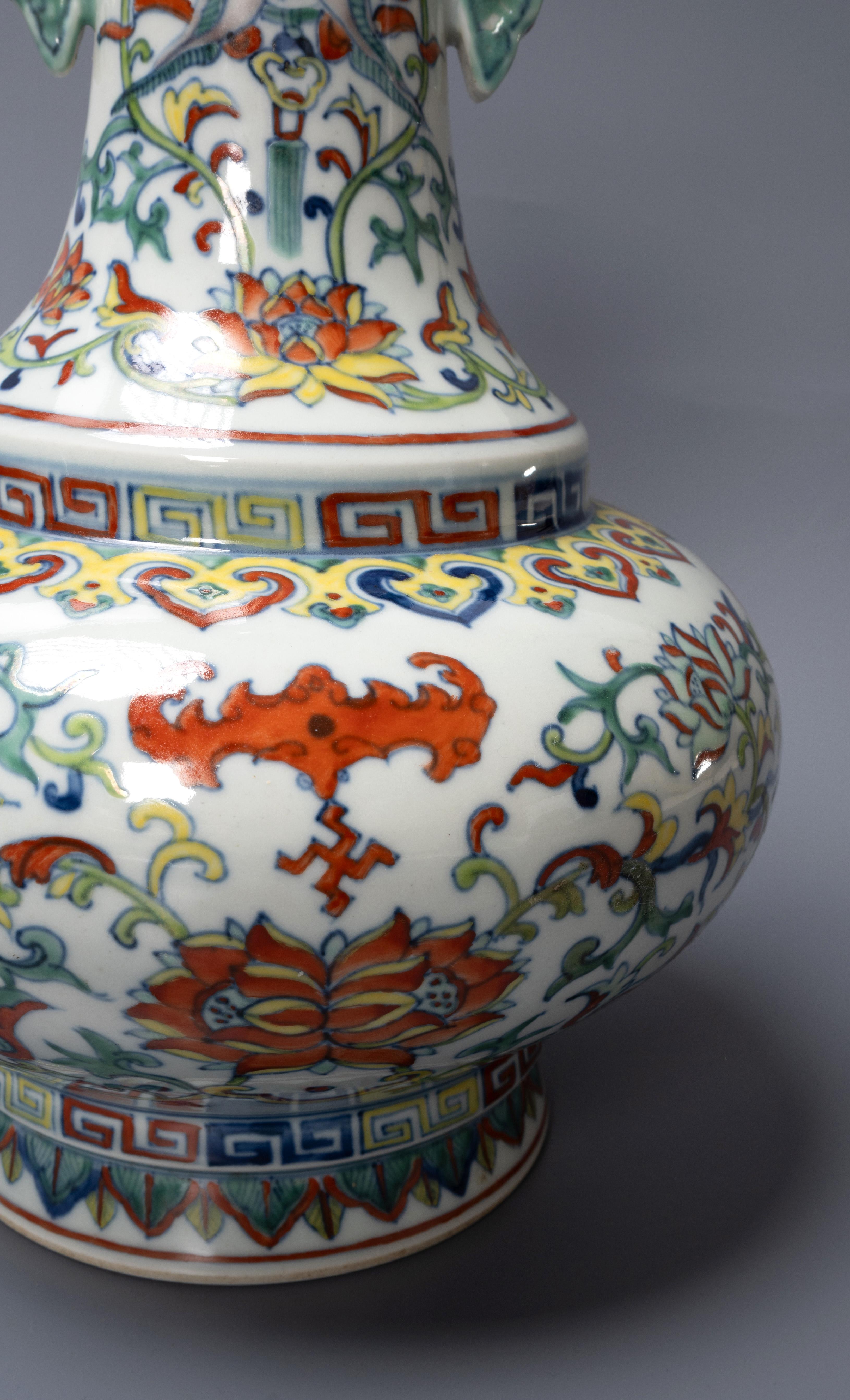 A CHINESE DOUCAI 'BATS AND LOTUS' VASE.
Yongzheng mark but later, the base with an apocryphal six-character mark, 
31cm high. The twin-handled vase painted with bats flying over large lotus flowers issuing from curling leafy stems.