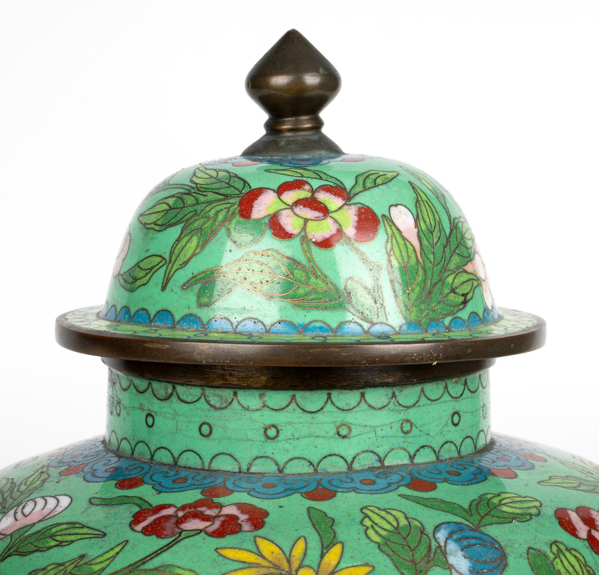 A stunning Chinese Republic Period cloisonne floral patterned lidded jar on its original fitted wooden stand dating from around 1920. The elegant and traditional shaped jar stands on a narrow round brass foot and is of tall round bulbous shape with