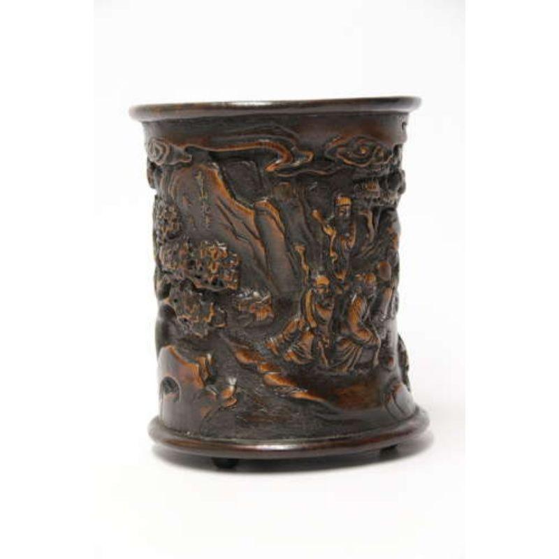 A Chinese carved bamboo and hardwood brush pot.

This large boldly carved Chinese brush pot is made from bamboo with a hardwood rim and foot. It is carved with good detail with a continuous scene of a large group of figures gathered together