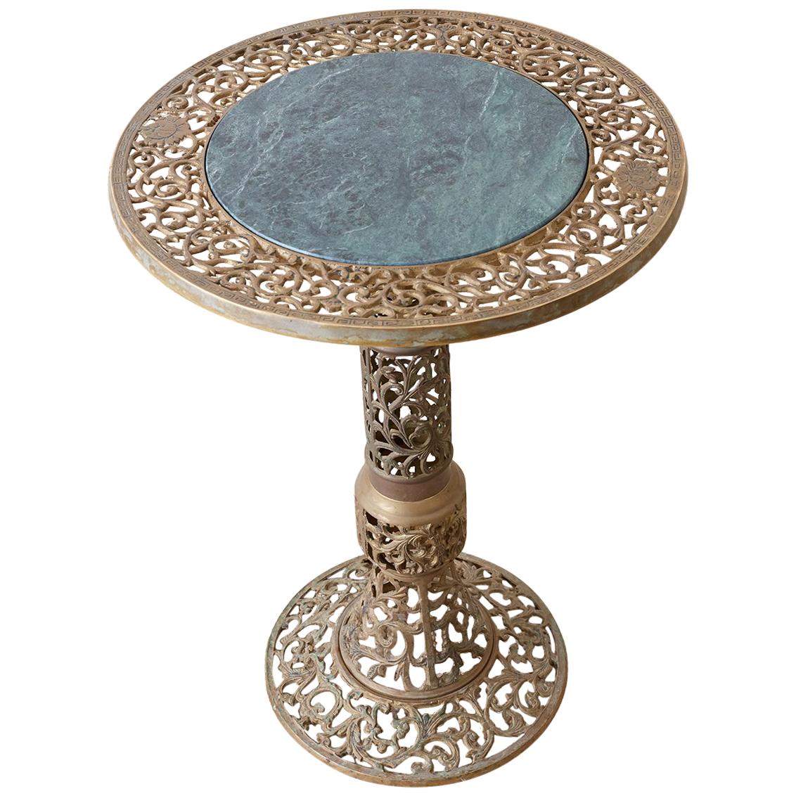 Stunning Chinese brass drinks table featuring a green marble top. The entire body of the piece is decorated with a pierced or reticulated open fretwork pattern in a vine and foliate motif. Round top and base conjoined by a thick column. Originally a