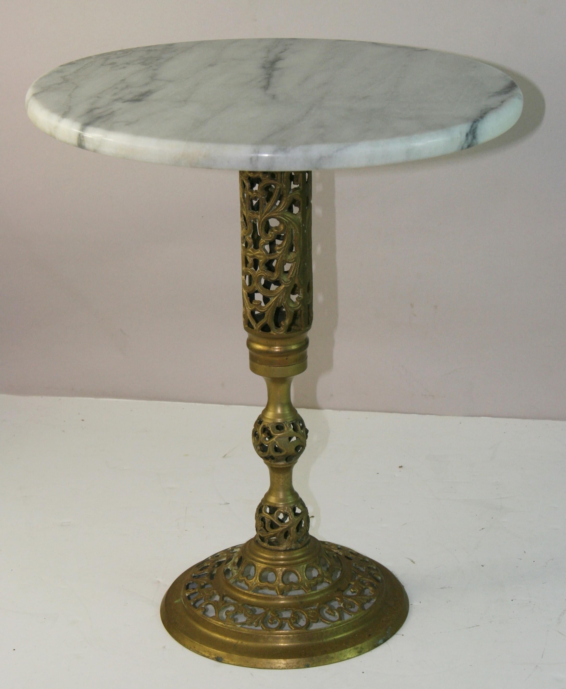 5219 Stunning Chinese Hollywood Regency brass drinks table featuring Carrara marble top.
The pedestal base is decorated with  PIERCED OR RETICULATED OPEN FRETWORK Pattern with a vine motif'
The brass has a beautifully aged patinated finish.
Similar