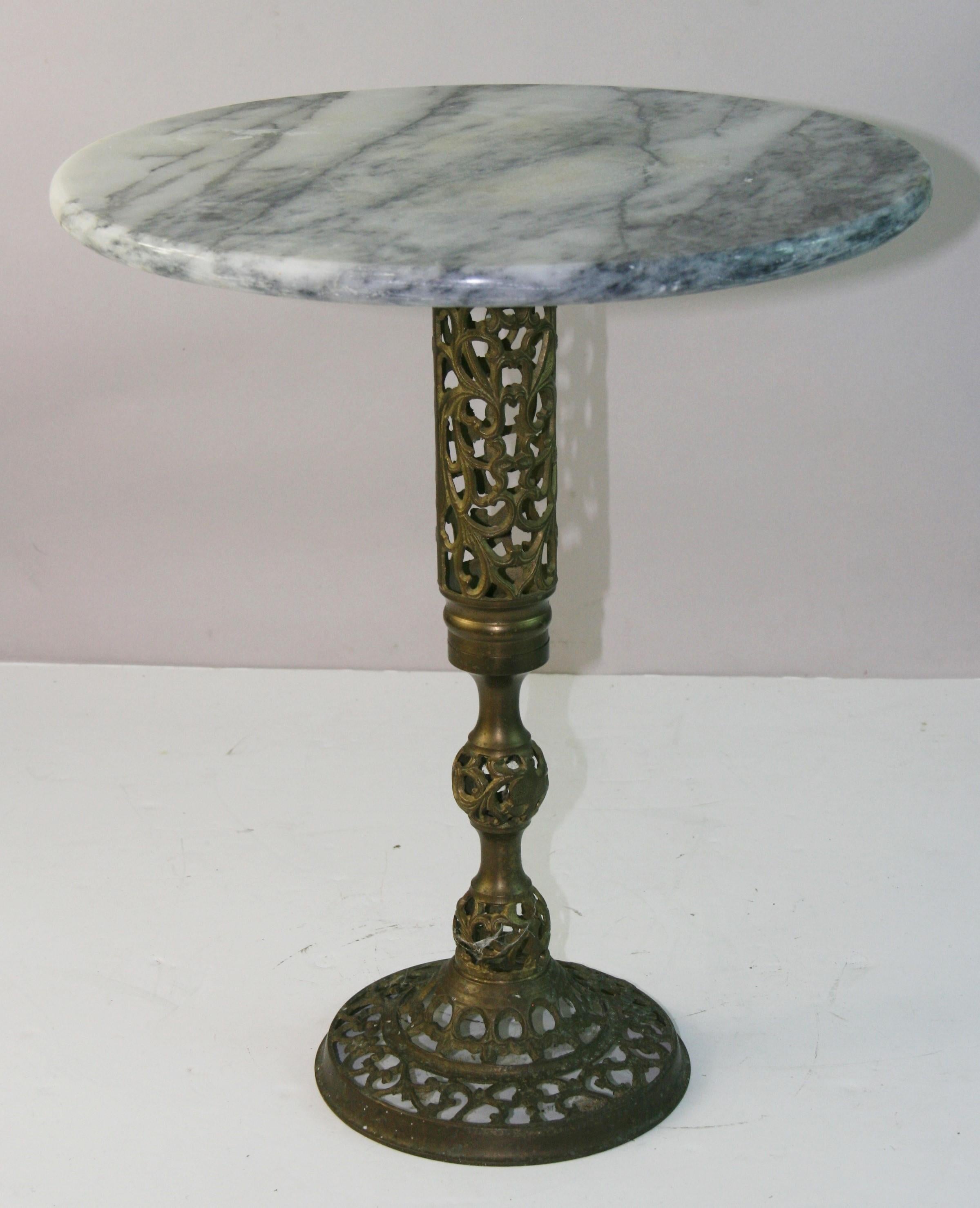 5222 Stunning Chinese Hollywood Regency brass drings table featuring Carrara marble top with black veining.
The pedestal base is decorated ith pierced or reticulated open fretwork pattern with vein motiff.
The brass has an aged patina finish
Similar