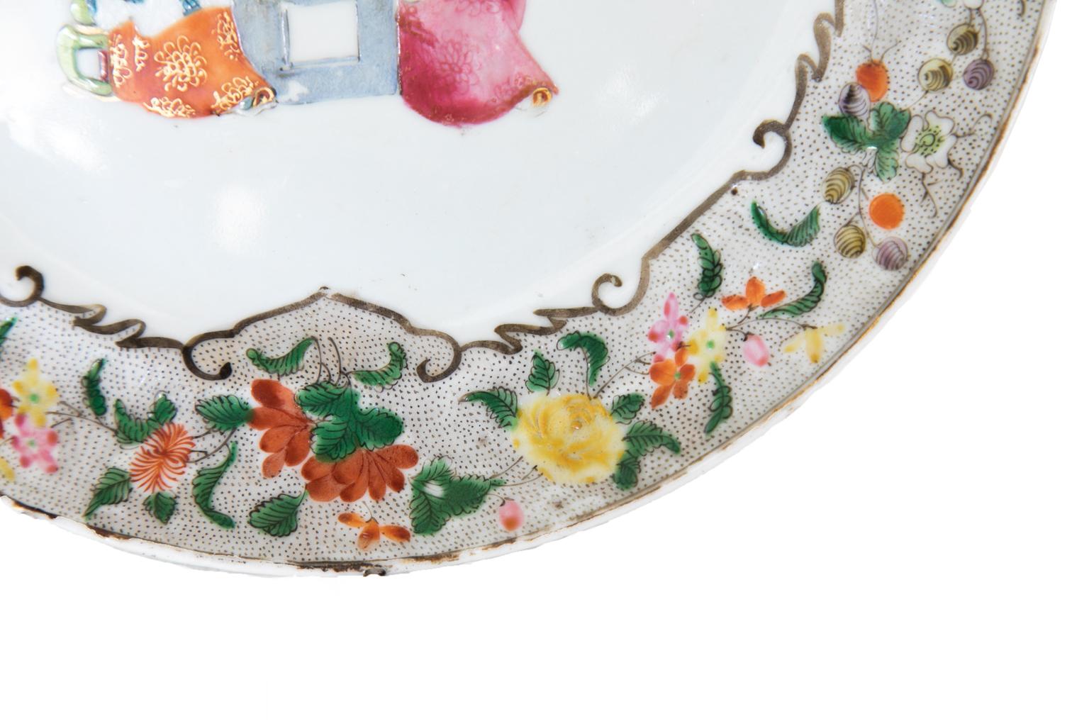 Chinese rose mandarin plate, depicting mandarins, with attendants, playing a board game. It has a floral patterned border with a stippled background.