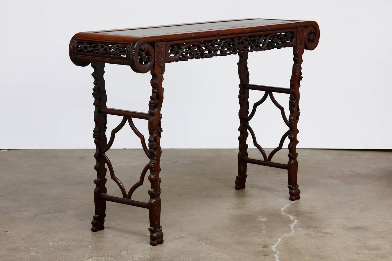 Fantastic and radiant grain is featured on the exceptional top panel of this Chinese Huali rosewood table with remarkably straight patterns. Aprons are carved in an intricate lattice work of blossoms and birds. The legs feature delicate faux bois