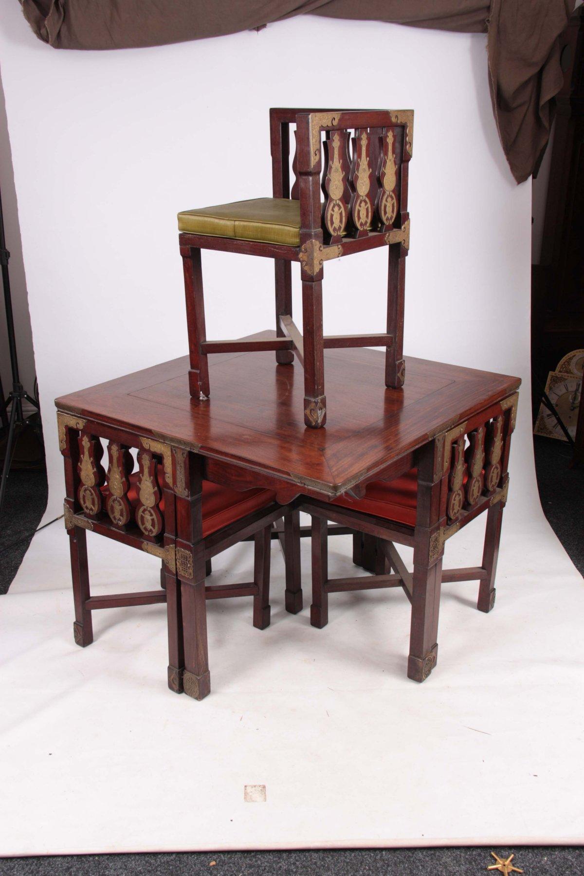 A rare late 19th-century Japanese export square dining table with four matching corner chairs that stow nicely away underneath. The base with four outer legs and a central leg is united by a high spaped cross stretcher. The four corner chairs with