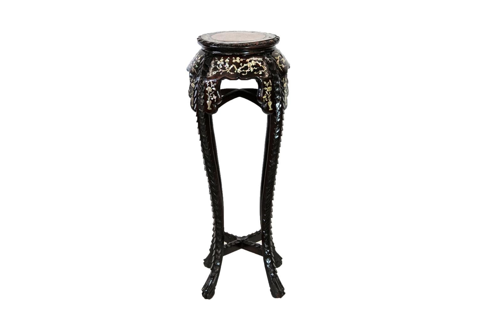 This Chinese rosewood inlaid stand is profusely inlaid with mother of pearl vines, flowers, limbs, and birds. The shaped leg supports are inlaid with mother of pearl vases and flowers. The top has an insert of shrimp marble and a gadrooned top edge.