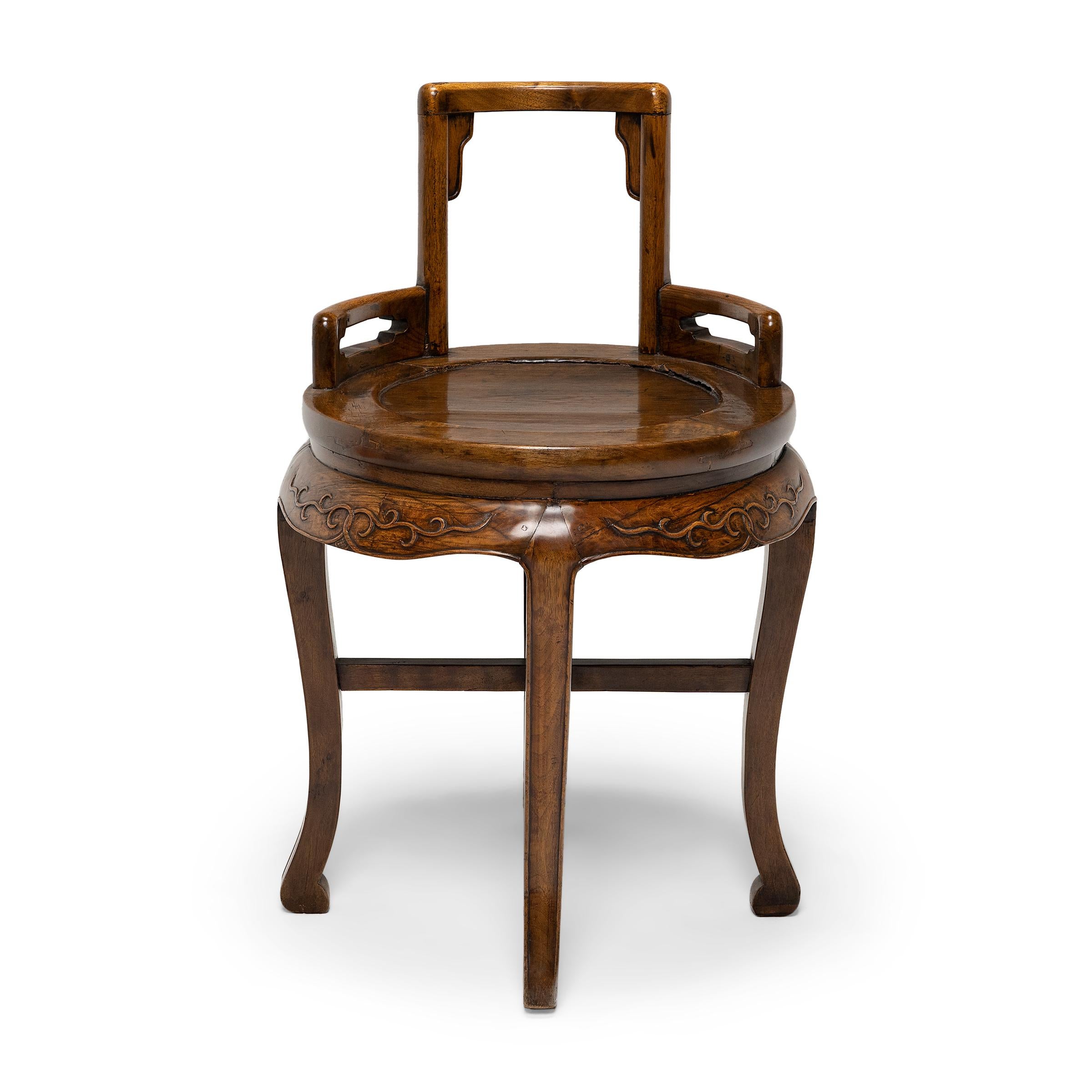 Dated to the late 19th century, this petite ladies' chair combines the low, square back of traditional rose chairs with the round frame and cabriole legs of waisted display tables. The chair features an open back with shallow arms, curved to match