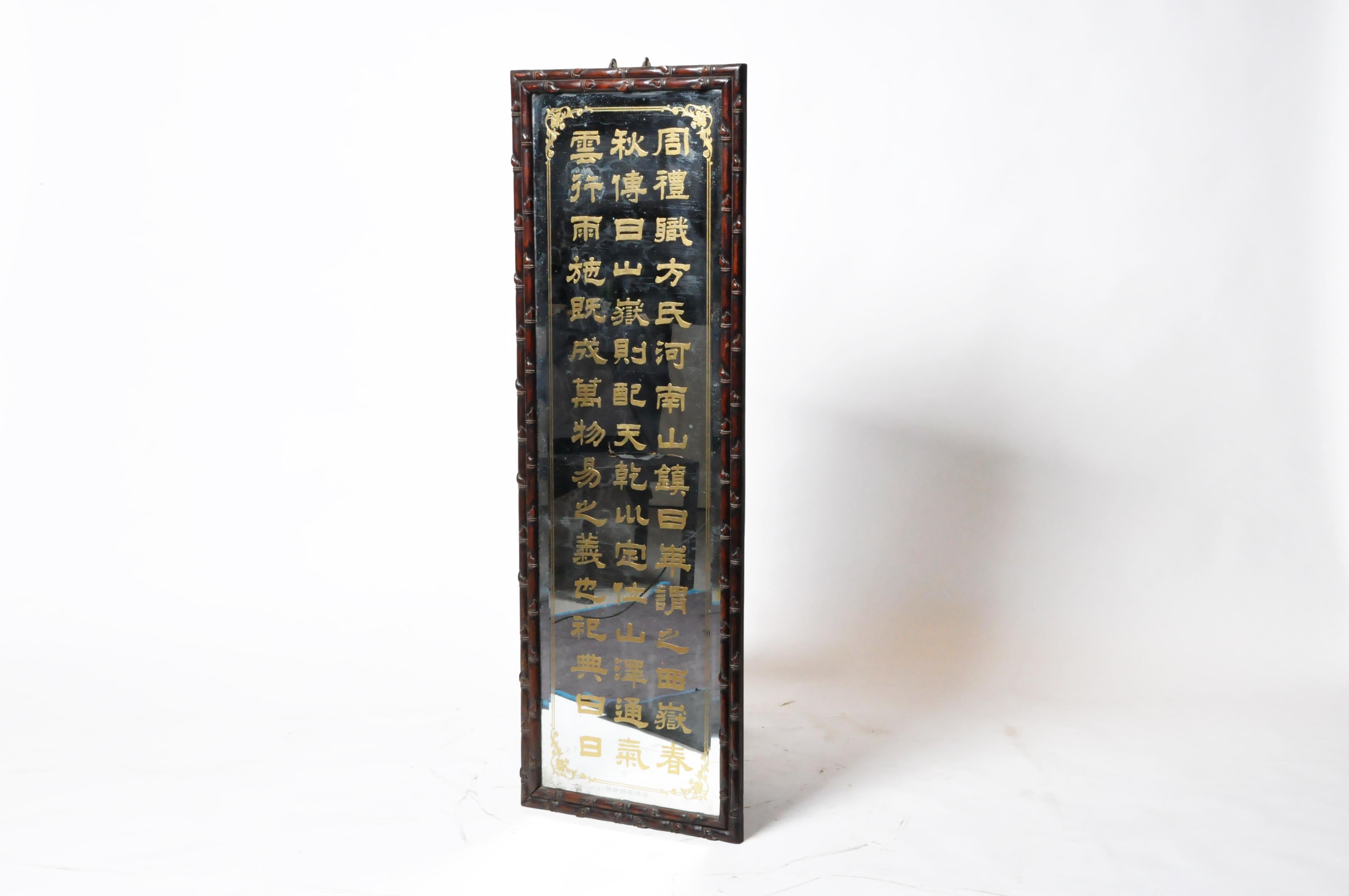 This Chinese mirror was made in Rangoon from rosewood and reverse-painted glass. The rosewood frame is extremely heavy and carved in a subtle bamboo pattern. The mirror was part of a series of 7 that was placed near the entrance to a Chinese-Burmese