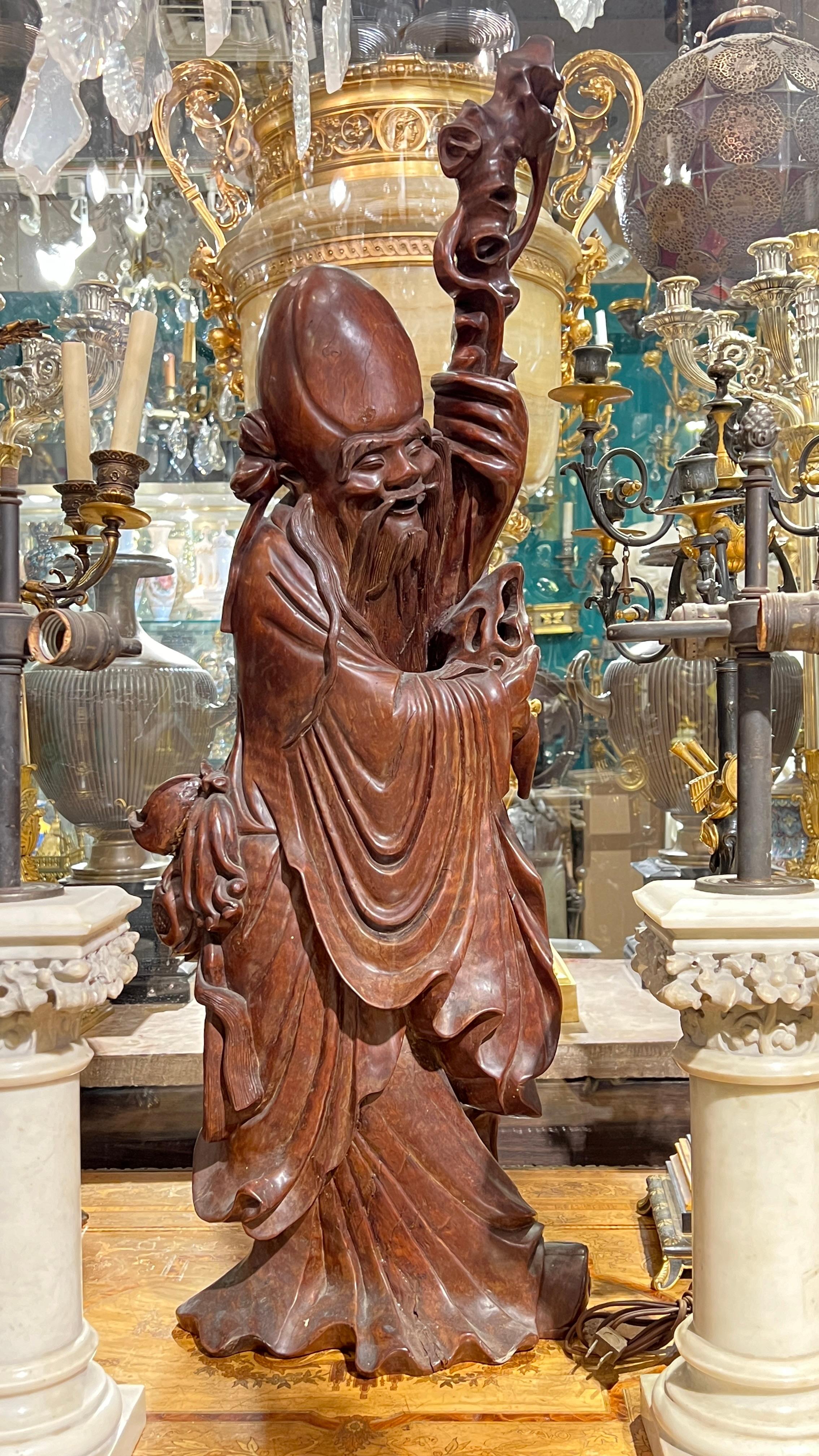 Chinese carved rosewood sculpture of a Daoist deity measuring 36 inches tall.
