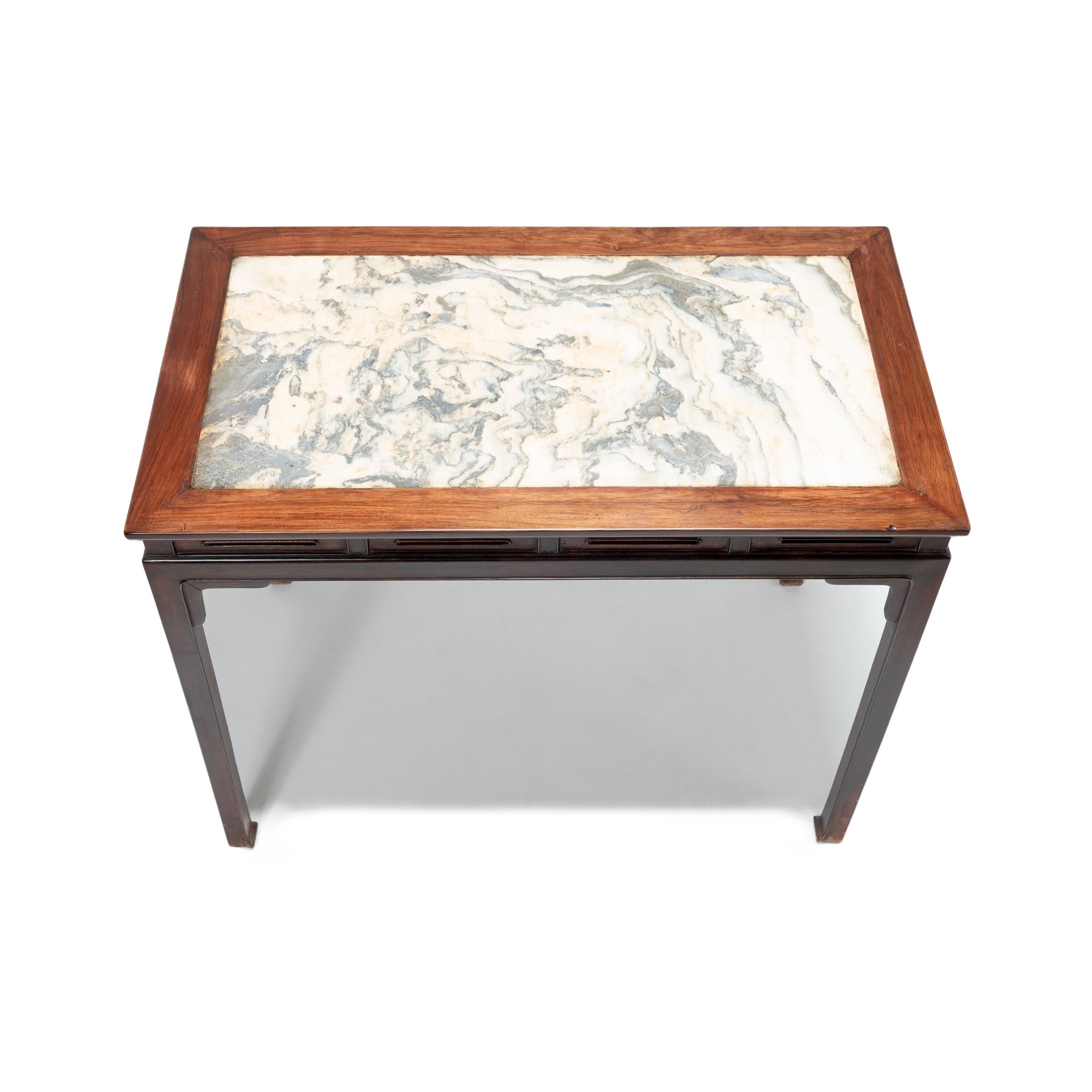 This vintage hardwood table from Beijing was crafted with graceful proportions in the manner of Ming design. It features a hand carved beaded apron, square legs ending in hoof feet, and a marble top selected for its resemblance to a Chinese