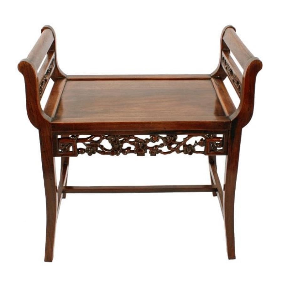An early 20th century Chinese carved rosewood window seat or stool.

The stool has square kick out legs with a 'H' shaped cross stretcher and the raised sides have a carved fret work panel with a rail above.

The front of the stool has a carved