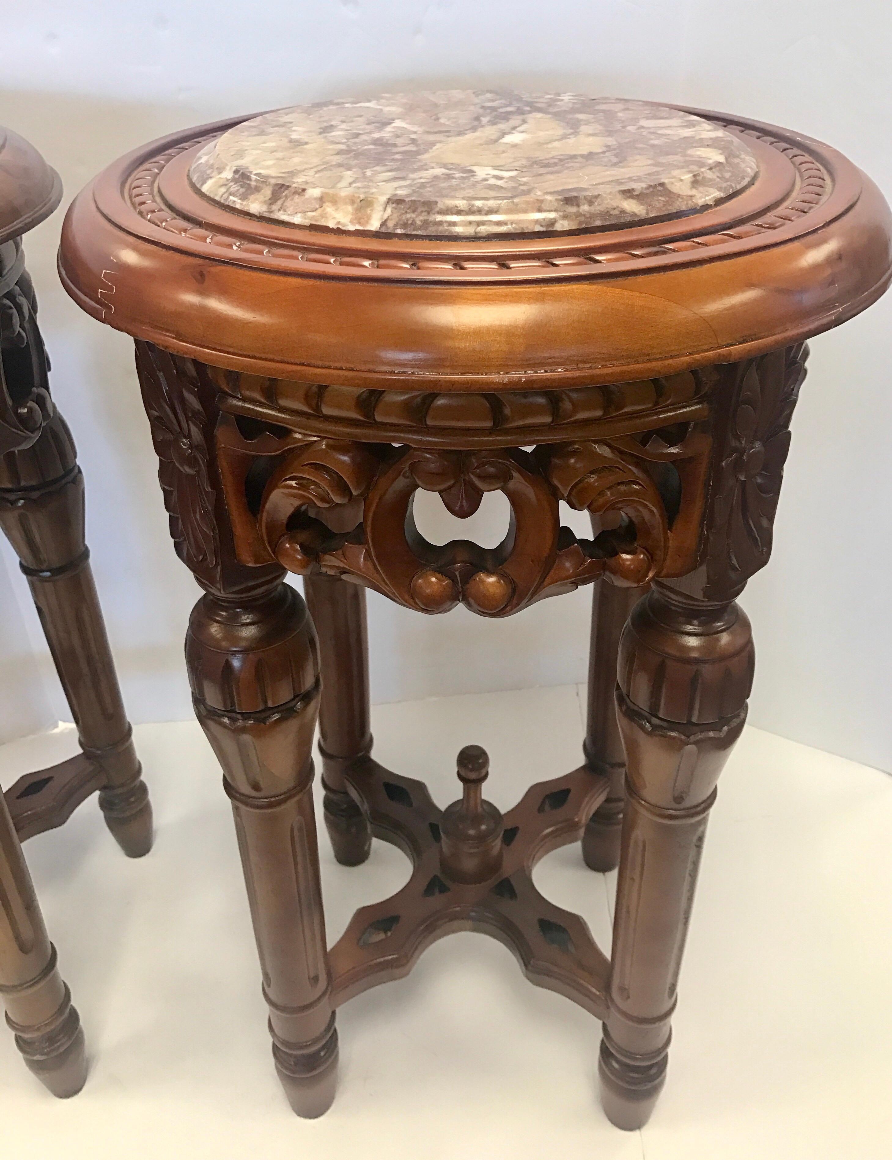 Intricately carved pair of wooden Chinese pedestals with marble insert at top. Gorgeous scale to these pieces.