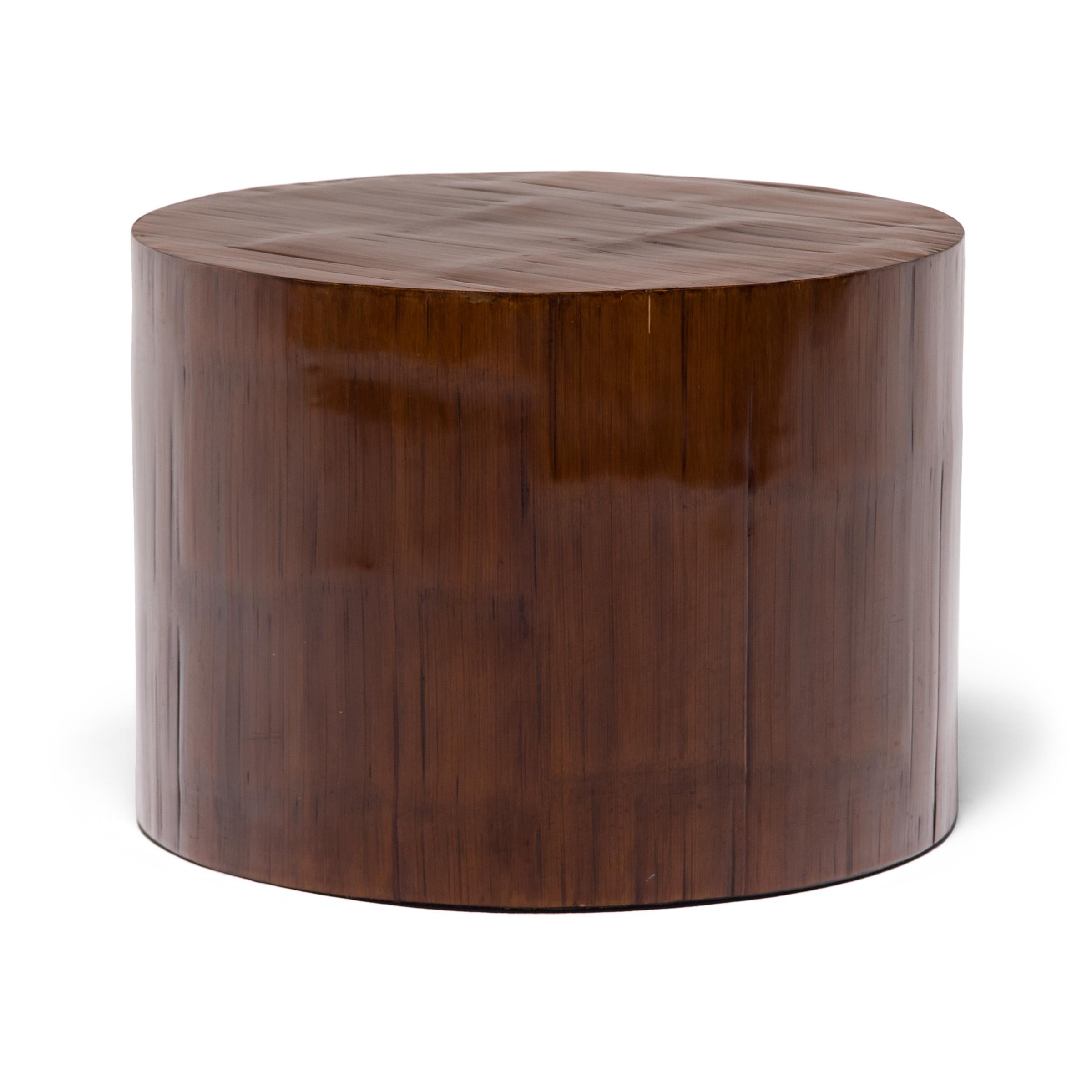 This round pedestal table from Guangzhou, China has an effortless design that works itself seamlessly into any interior. Crushed bamboo brings subtle texture to its minimal form and a finish of chestnut brown lacquer brings out its sculptural