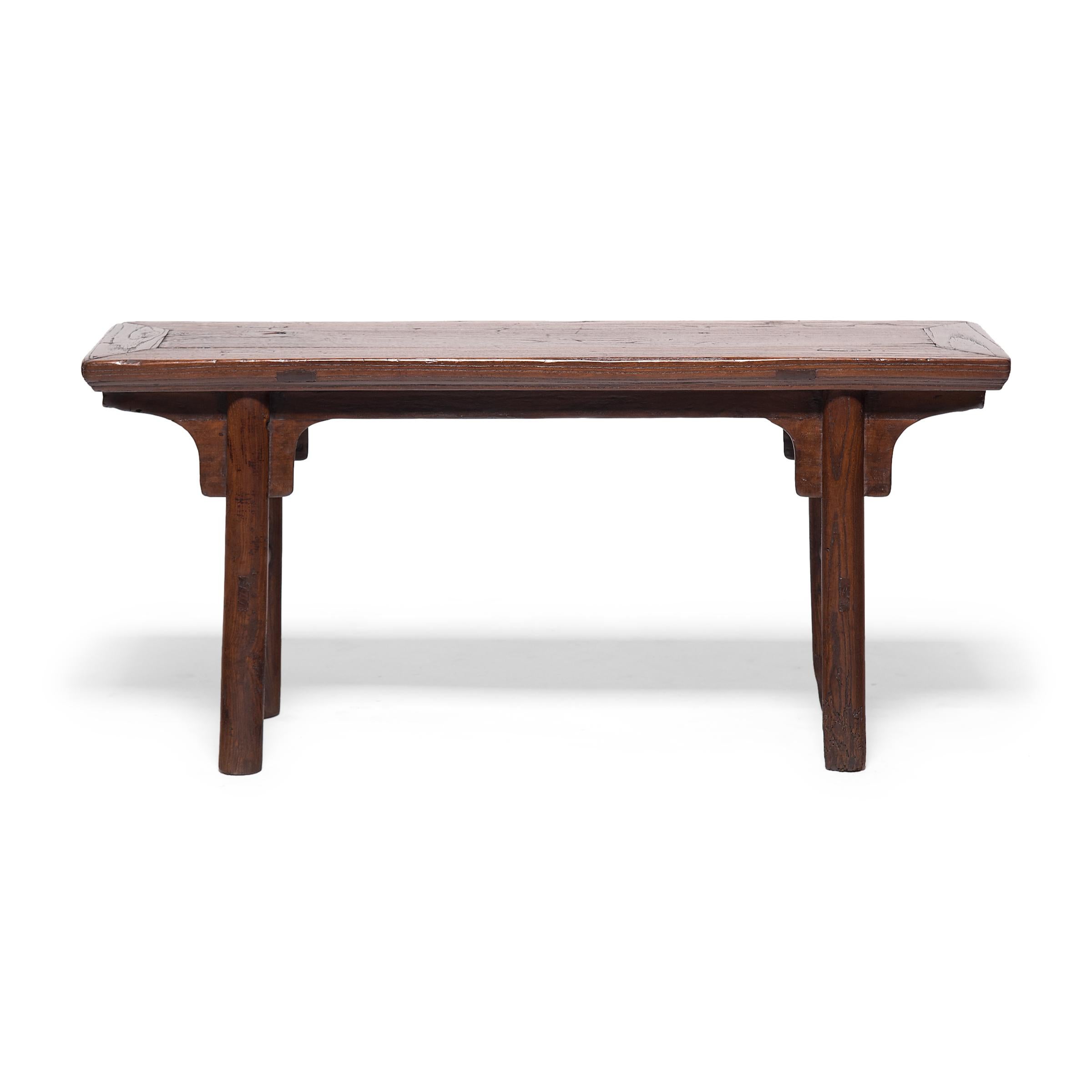 Ce banc en bois d'orme du début du XXe siècle se trouvait à l'origine dans la cour d'une maison de la dynastie Qing et permettait de s'asseoir à l'extérieur pendant les chaudes journées d'été. Le banc est conçu dans un style Ming classique, avec un