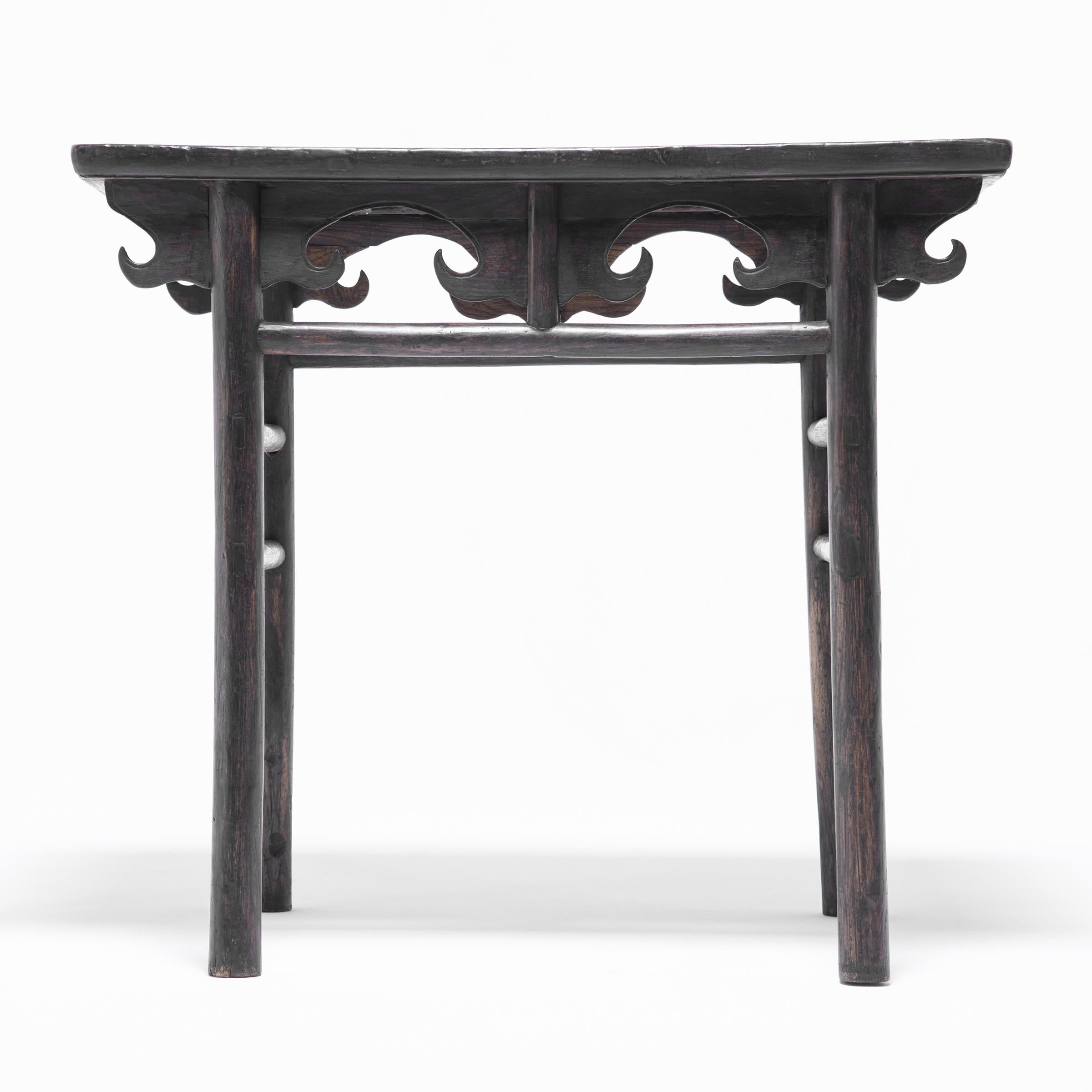 This exquisitely crafted elmwood table was made over 150 years ago in the Shanxi region of China. The simple and sophisticated construction is dramatically highlighted by the way the spandrels come together with the spirited apron motif to create a