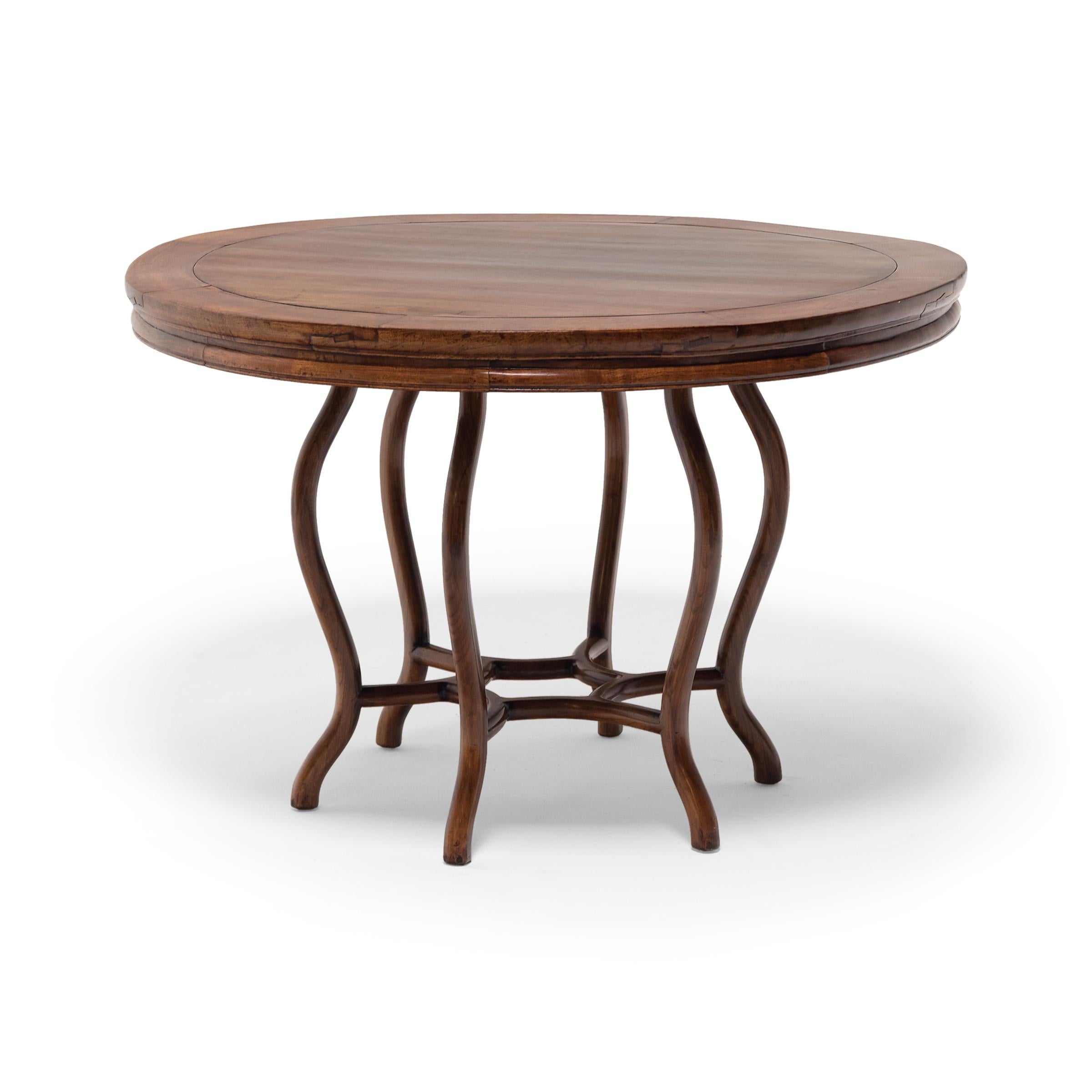 With an expansive round tabletop and sinuous curved legs, this late 19th century tea table was likely designed with Western tastes in mind. The round table was crafted in Zhejiang province, the round table is constructed of a Chinese hardwood with