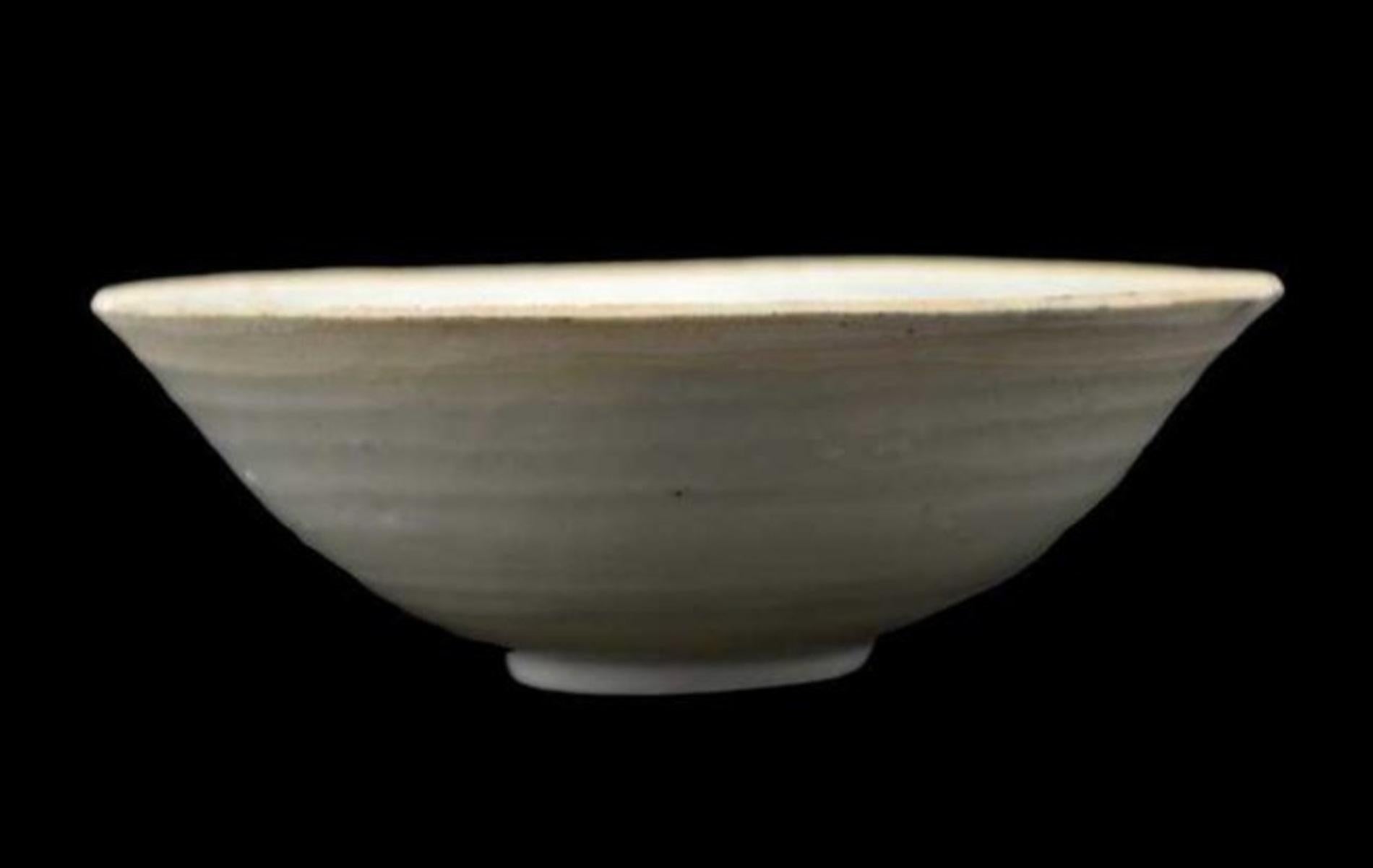 A fine rounded conical bowl
Chinese, Song dynasty, 12th-13th century
with twin fish motif in the well. Thinly potted translucent porcelain with unglazed rim and foot covered inside and out with a lavender blue gaze thinning to mushroom on the