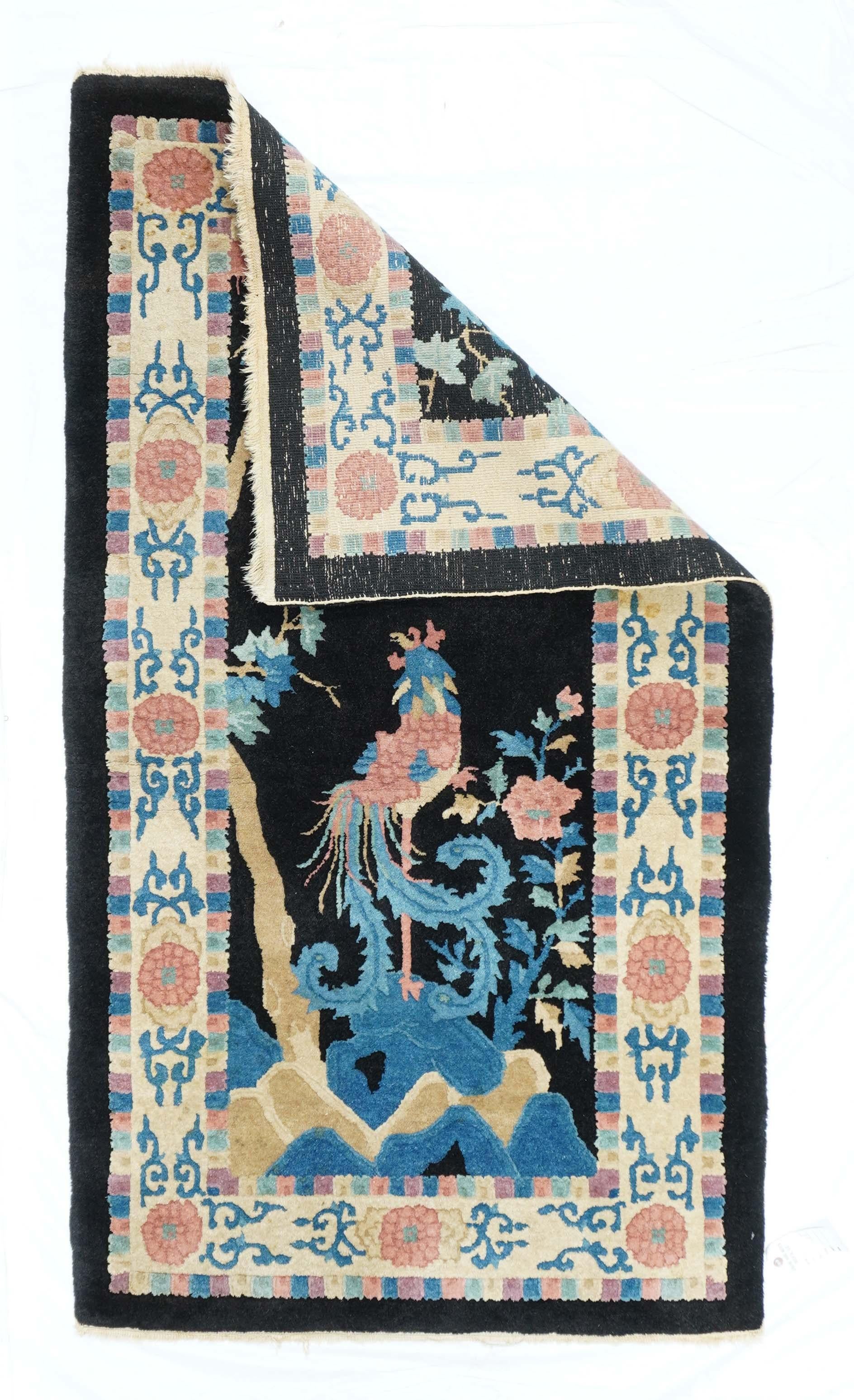 Antique Chinese Rug 3'1'' x 5'6''. A fanciful bird with barbed, curling tail feathers, stands on one leg under a tree and on multicolored rocks, against a navy ground. Ecru border with chrysanthemum rosettes and arabesque fragments. Recent. Medium