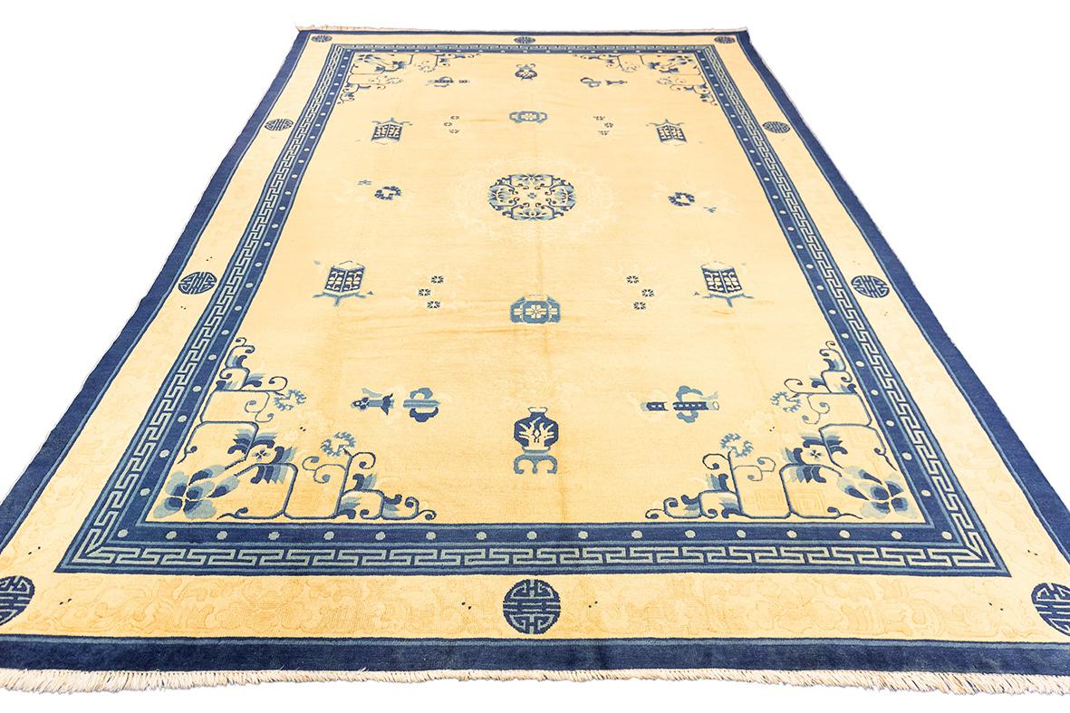 Esta alfombra china de Pekín, de 195 x 290 cm, muestra la refinada elegancia característica de la artesanía tradicional china. El cálido campo amarillo dorado está adornado con motivos finamente detallados en azul oscuro contrastado, que incluyen