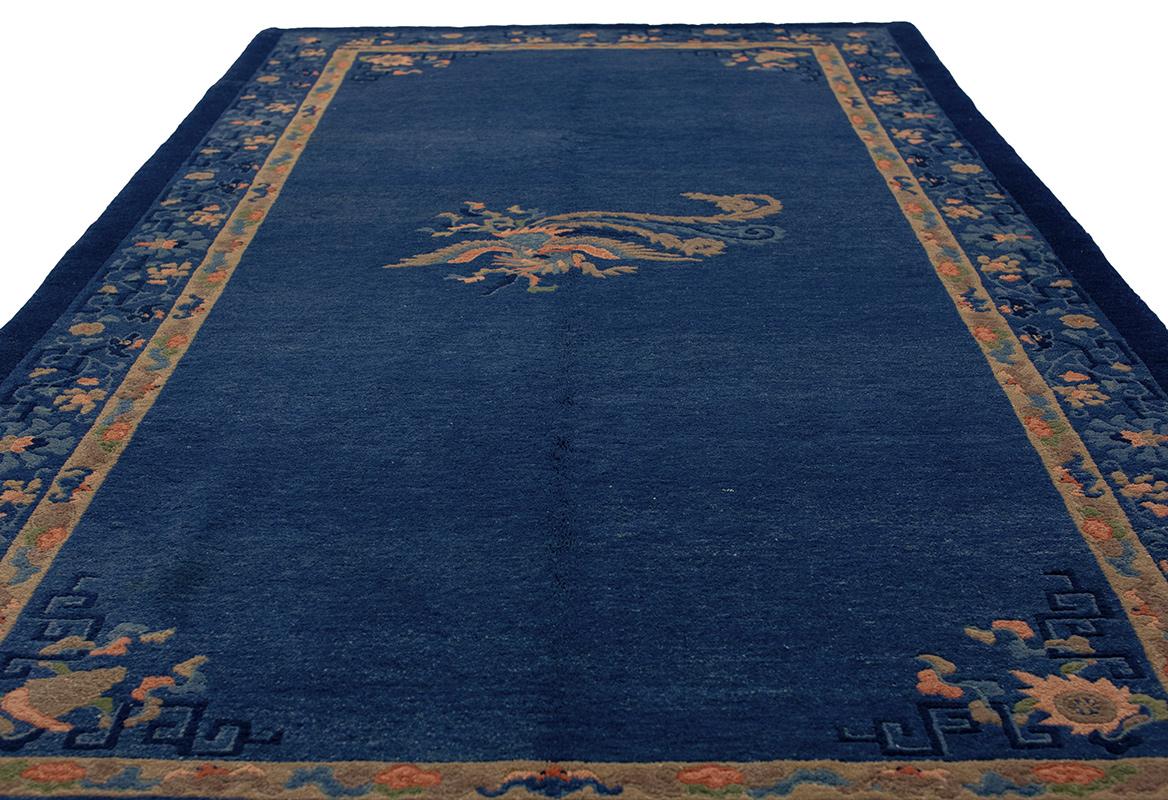 Ce tapis chinois ancien de Pékin, mesurant 151 x 295 cm, est un exemple stupéfiant de l'artisanat traditionnel chinois, alliant l'art et la fonctionnalité dans un design intemporel. Le champ bleu indigo profond du tapis est à la fois audacieux et