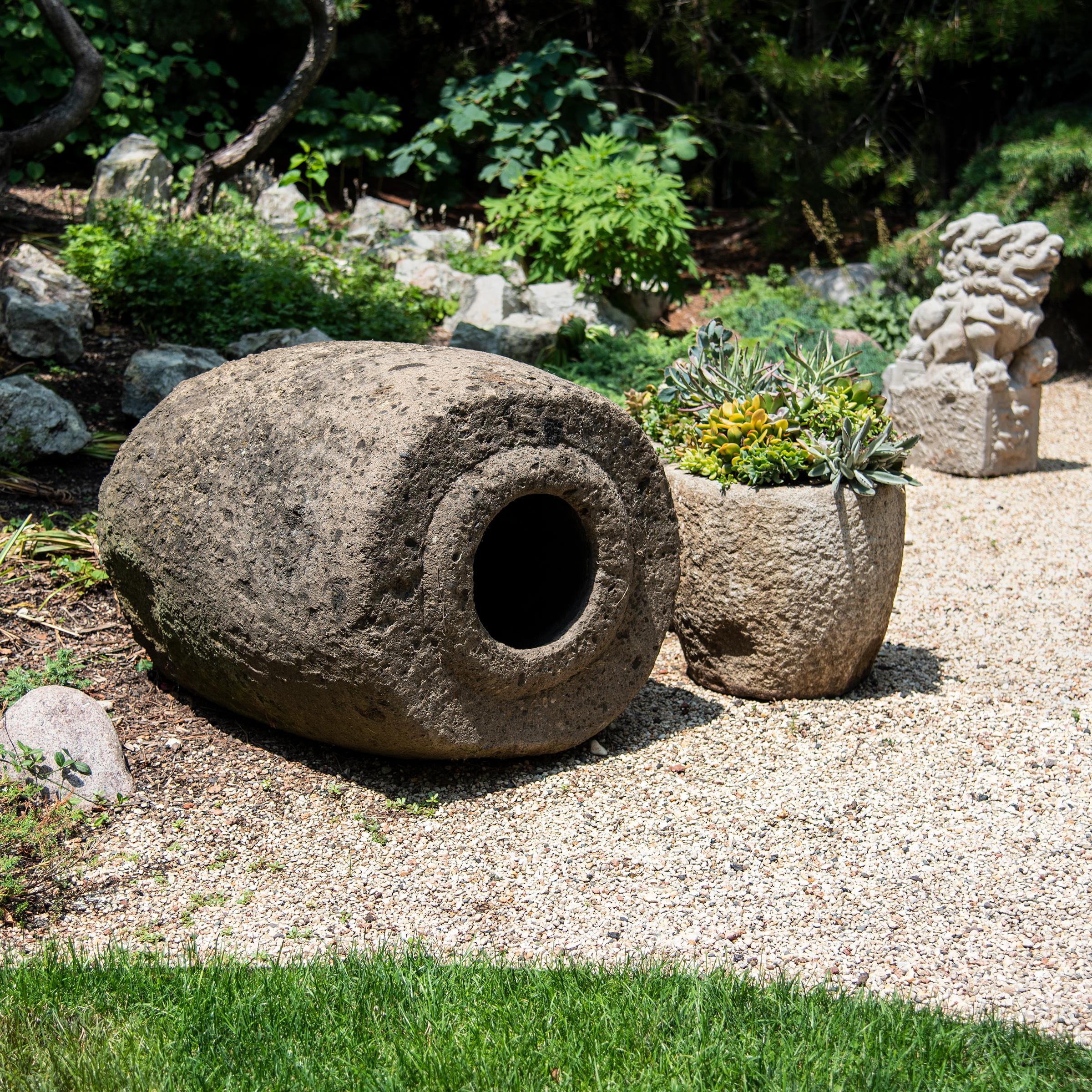 Simply shaped with an elegant form, this large limestone vessel is actually a runner stone, a key component to a traditional Chinese grain mill. Set atop an extensively carved mill stone, the runner stone was harnessed to a donkey or mule that