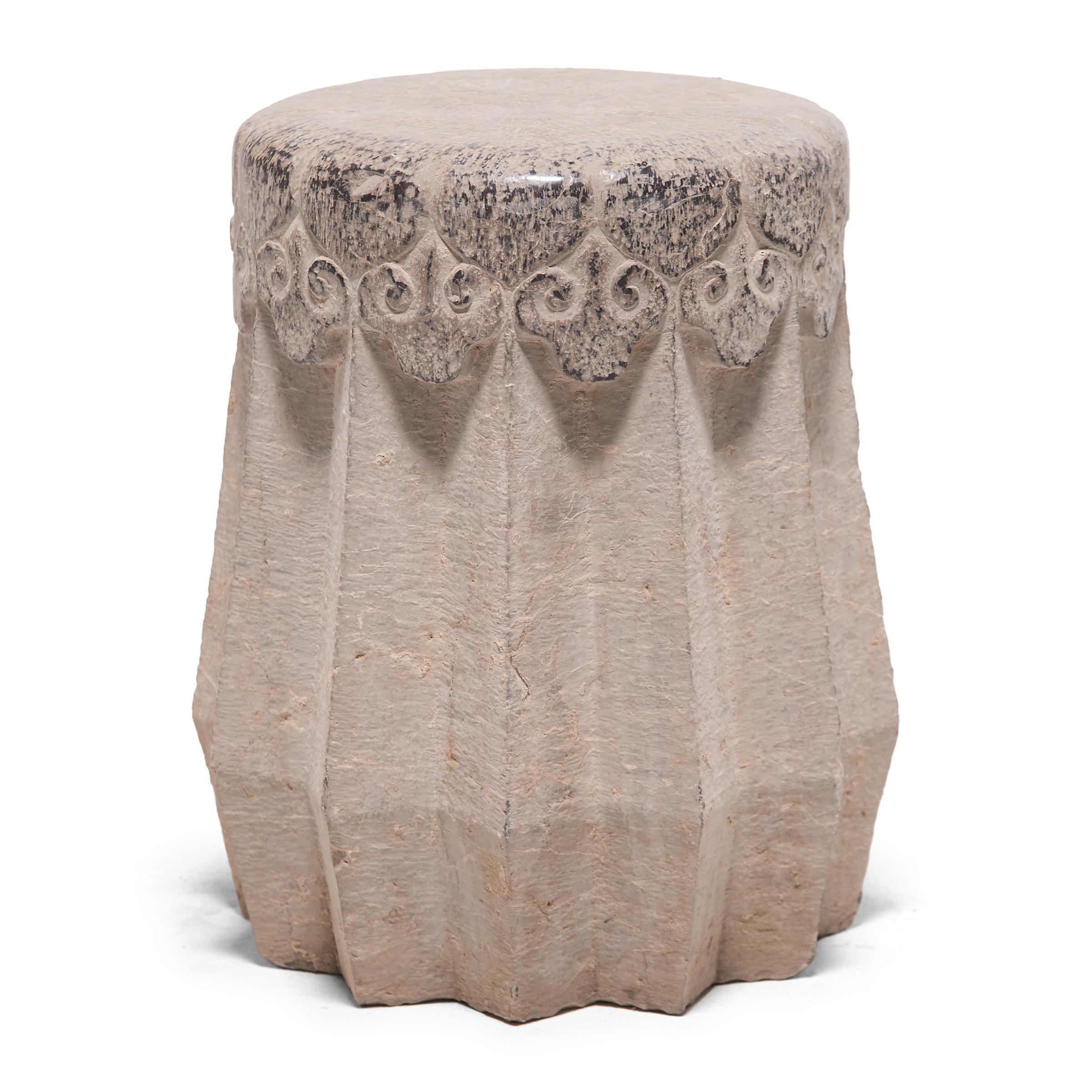 Carved from a solid block of limestone, this early 20th century drum stool began its life in China's Shanxi province. A variation of the traditional melon form, the stool has angular ridges running down the sides in a zig-zag pattern. The smoothed
