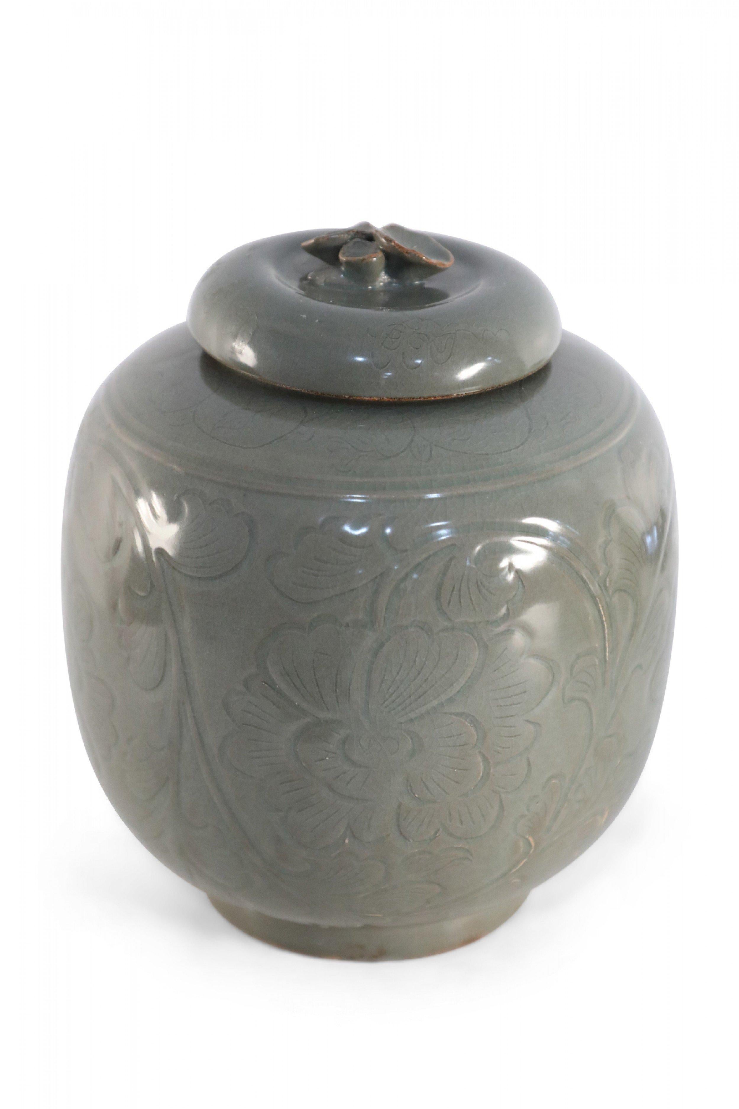 Chinese sage-colored, lidded porcelain jar crafted in the style of the Song dynasty with a round form decorated in a raised, tonal botanical pattern.