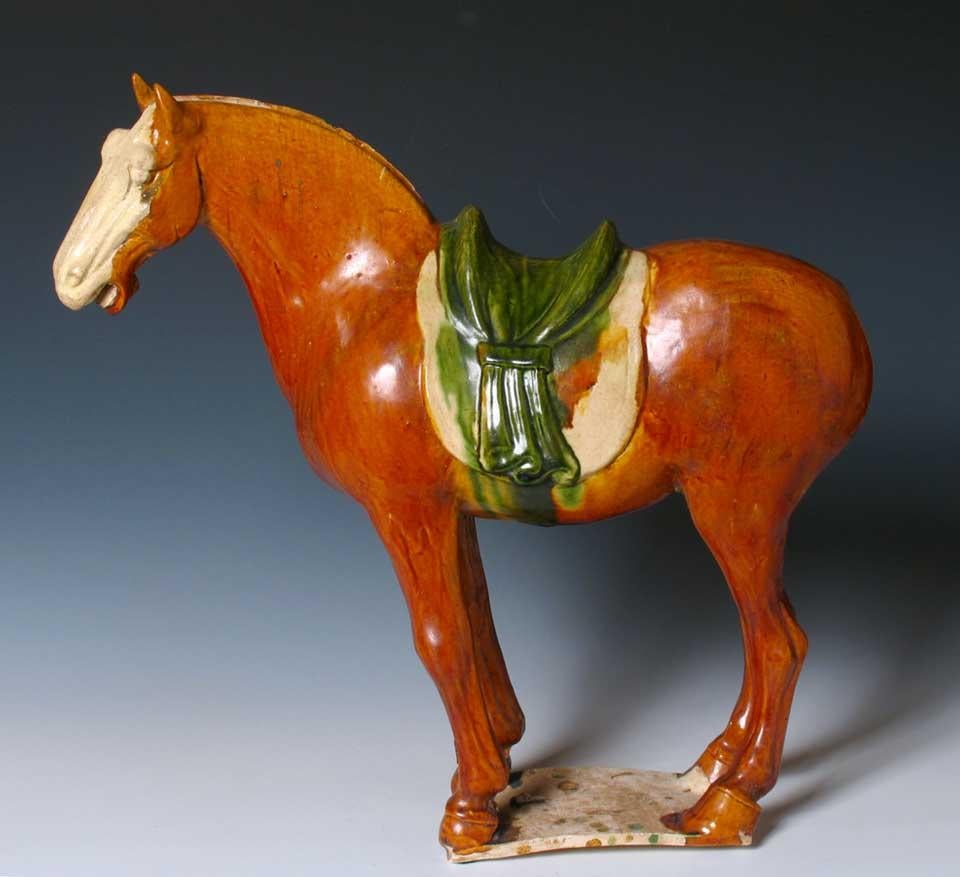 Chinese Sancai Glazed Tang Horse, funerary ceramic in the shape of a Fereghana stallion, standing four-square on a flat unglazed base, arched neck, well-defined head, ears pricked forward, groove along neck and aperture at tail for inserted