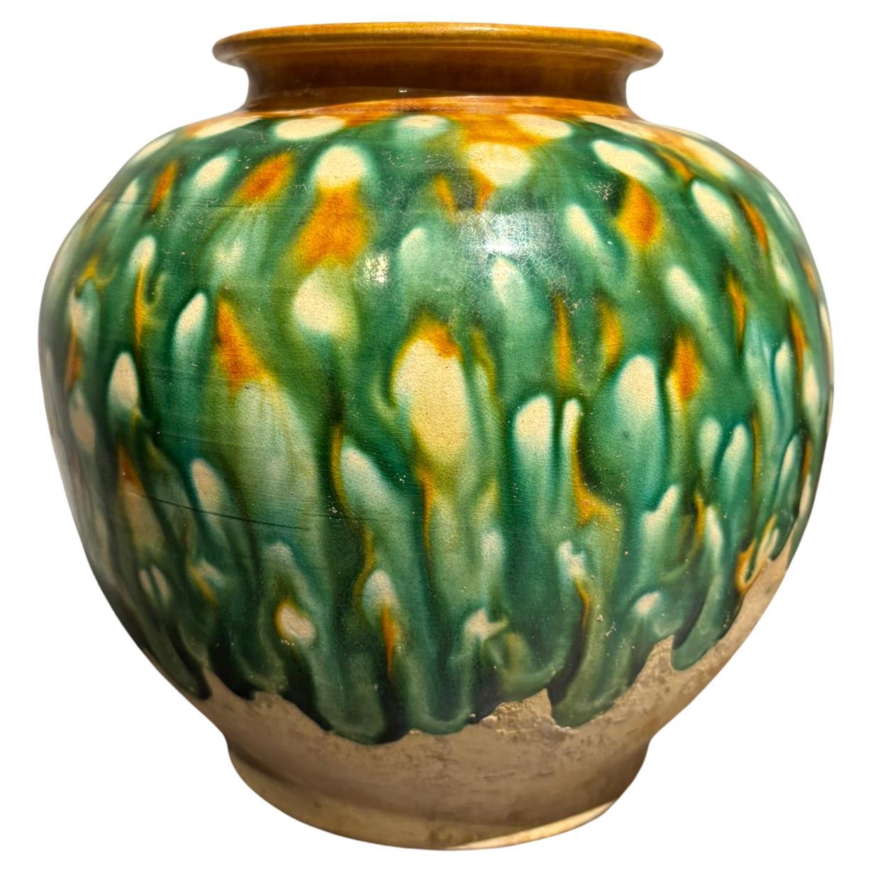 Chinese Tang Dynasty style Sancai glazed jar. This is a lovely example of Sancai glaze with the beautiful green, ocher and cream colors dripping down from the ocher rimand melding over three quarters of the surface with the bottom third showing the