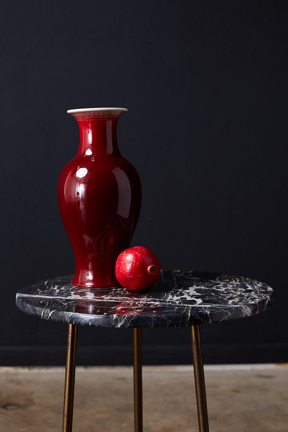 Beautiful Chinese export Sang de Boeuf oxblood glazed porcelain vase. Features an unusually deep oxblood color with a glossy finish on the Langyao glaze. Typical whitish vertical runs under the top rim and around the lip with interesting deep blue