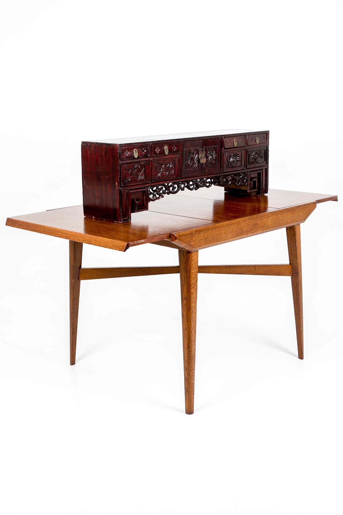 An ebonised burgundy Chinese scholar’s low kang hardwood cabinet. Featuring six small drawers, four across the top above a central cupboard that sits behind two doors and two hidden drawers, one on each side of the cabinet. With flora and fauna
