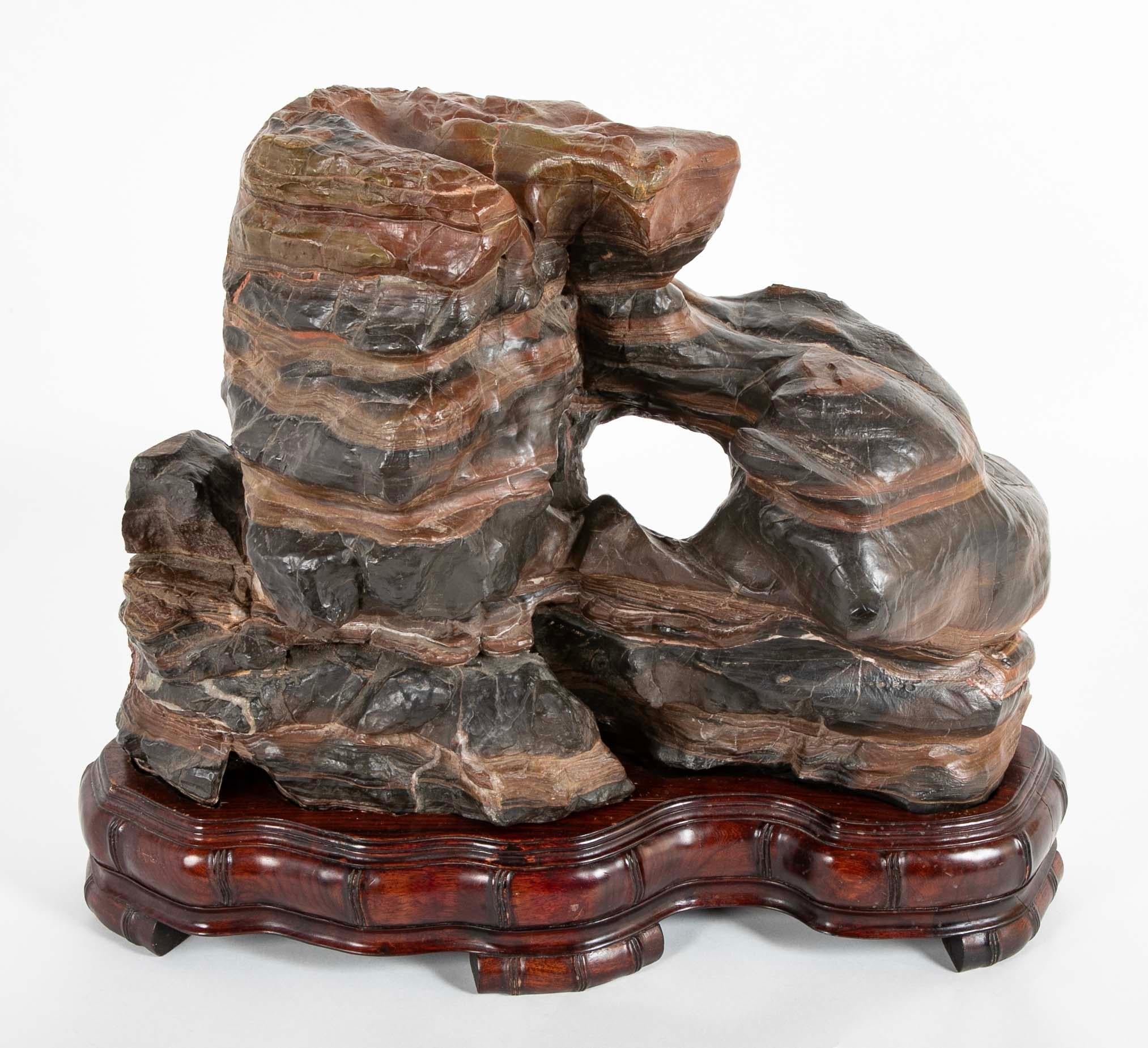 Sasso degli studiosi cinese, dinastia Qing, circa 1900 o prima, montato su una base di legno duro intagliato su misura. Questa roccia di grandi dimensioni è un ottimo esempio, con bellissime striature di pietra più chiara e più scura. Una singolare