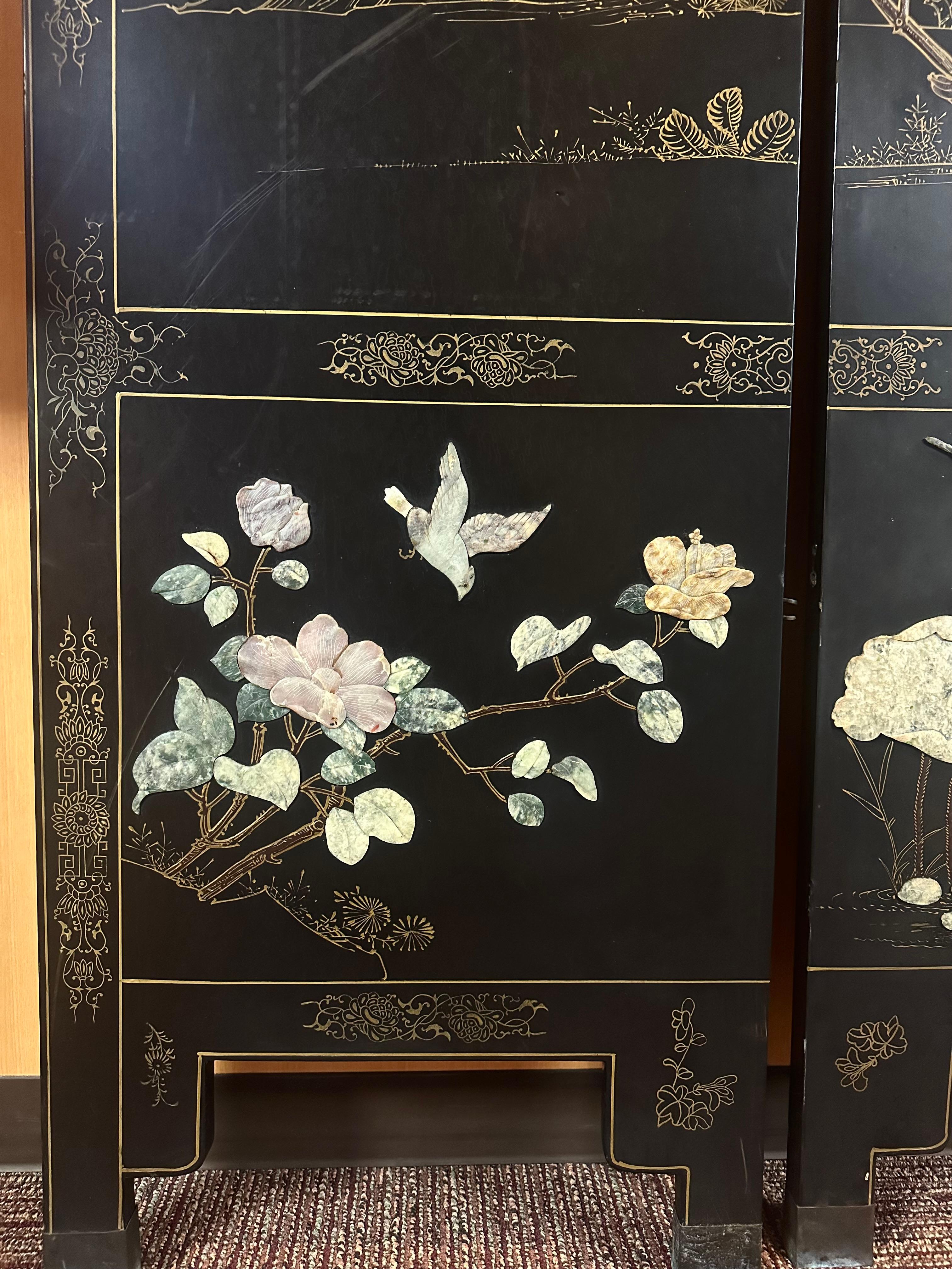 This magnificent Chinese folding screen captivates with its deep black lacquer surface, richly adorned with inlays of semi-precious stones. The composition depicts a luxuriant garden scene — blooming peonies and magnolias, rocks, and fluttering