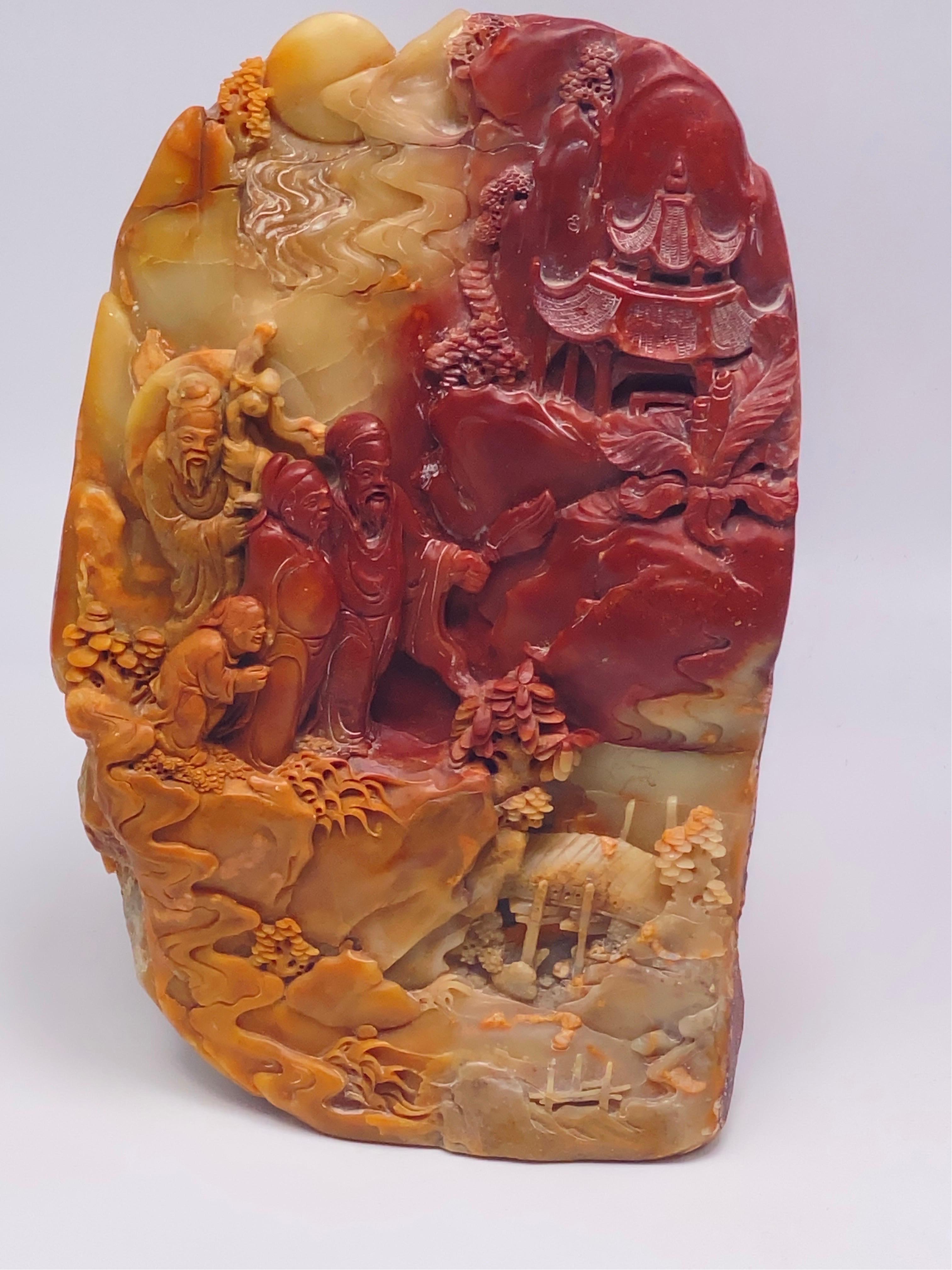 This a sculpture of a group of carachters, a village, on the mountain. In Serpentine stone, in Beige and red color. Very heavy.