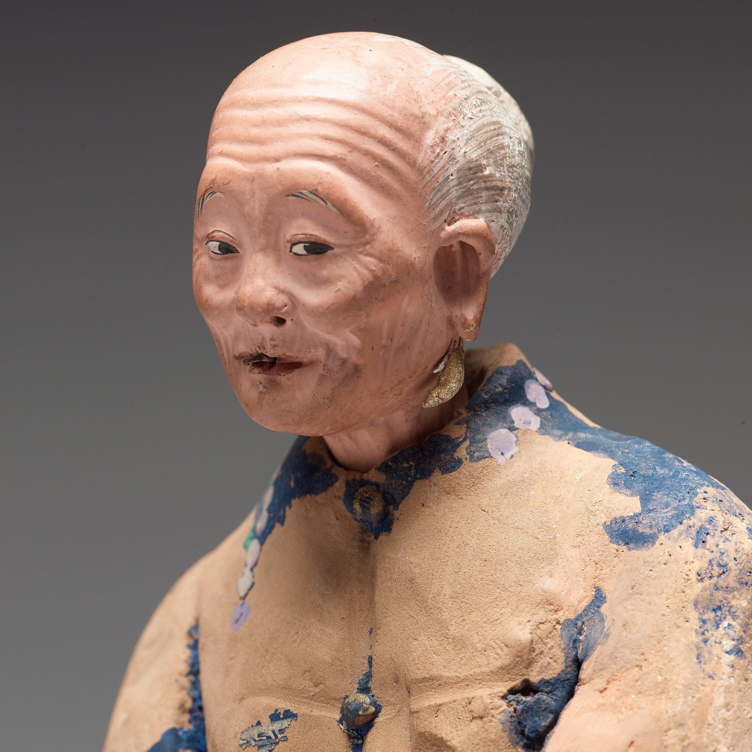 A Chinese sculptured and painted clay figure of an elderly man, 19th century. Partly worn off paint and probably missing a pair of feet.