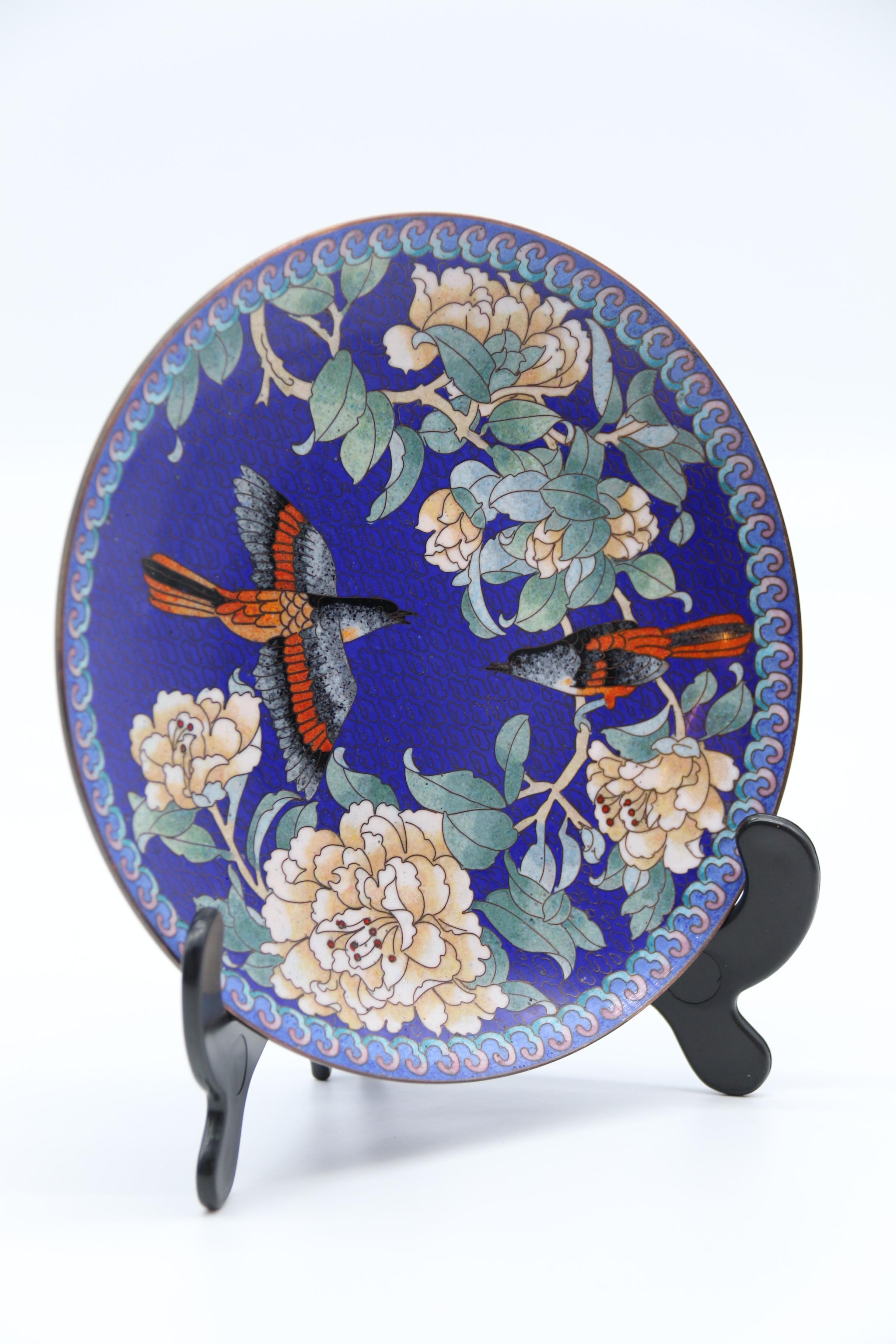 This beautiful and vibrant set of four Chinese cloisonne wall or cabinet plates is most eyecatching.  The design of exotic birds amongst branches with a flowering blossom is very well done with fine wires forming the design over a brass base which