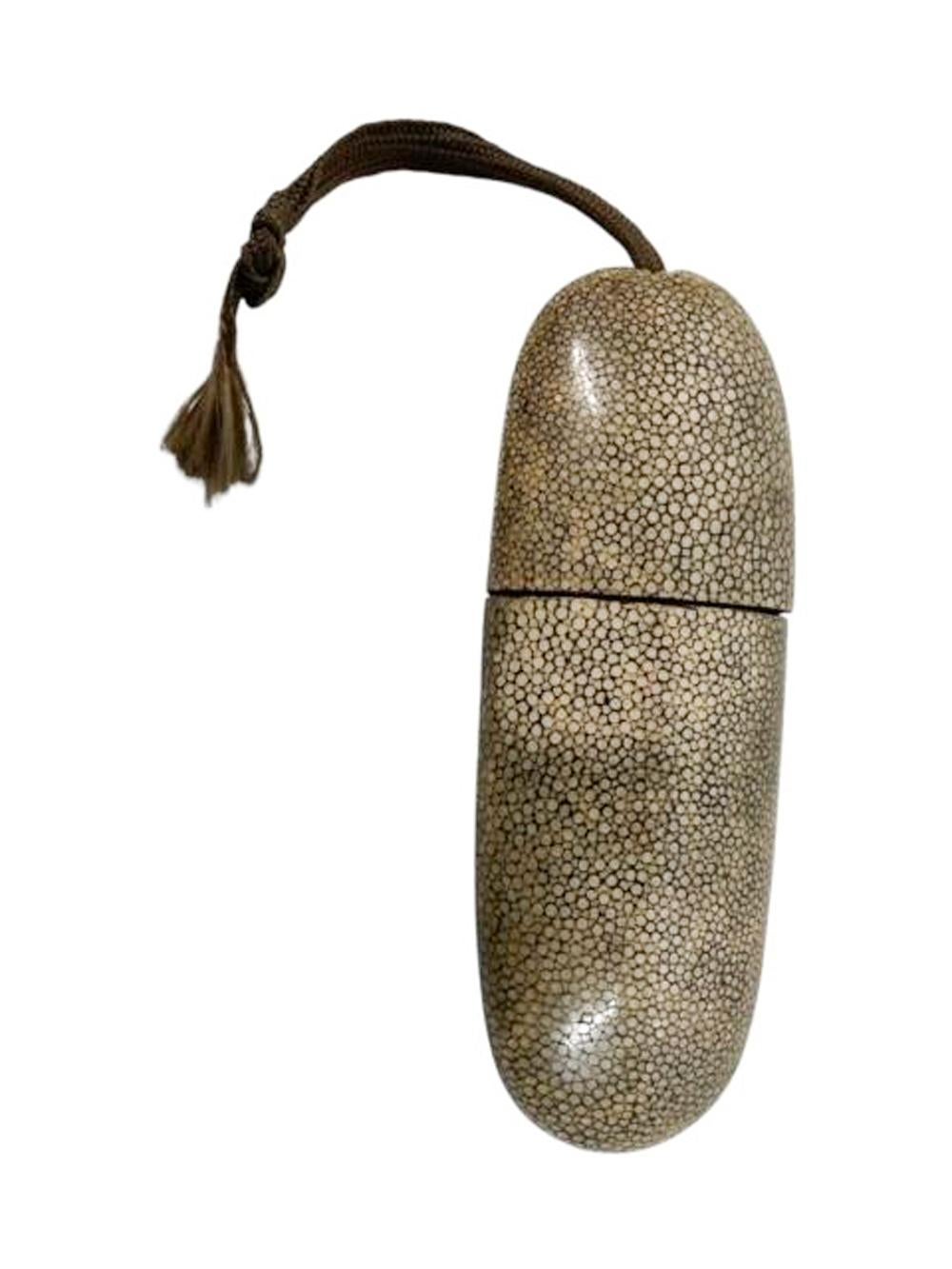 Estuche chino para gafas de forma tubular aplanada con los extremos cerrados, que se abre deslizándose en el centro y está hecho de papel maché recubierto de piel de zapa gris natural. 