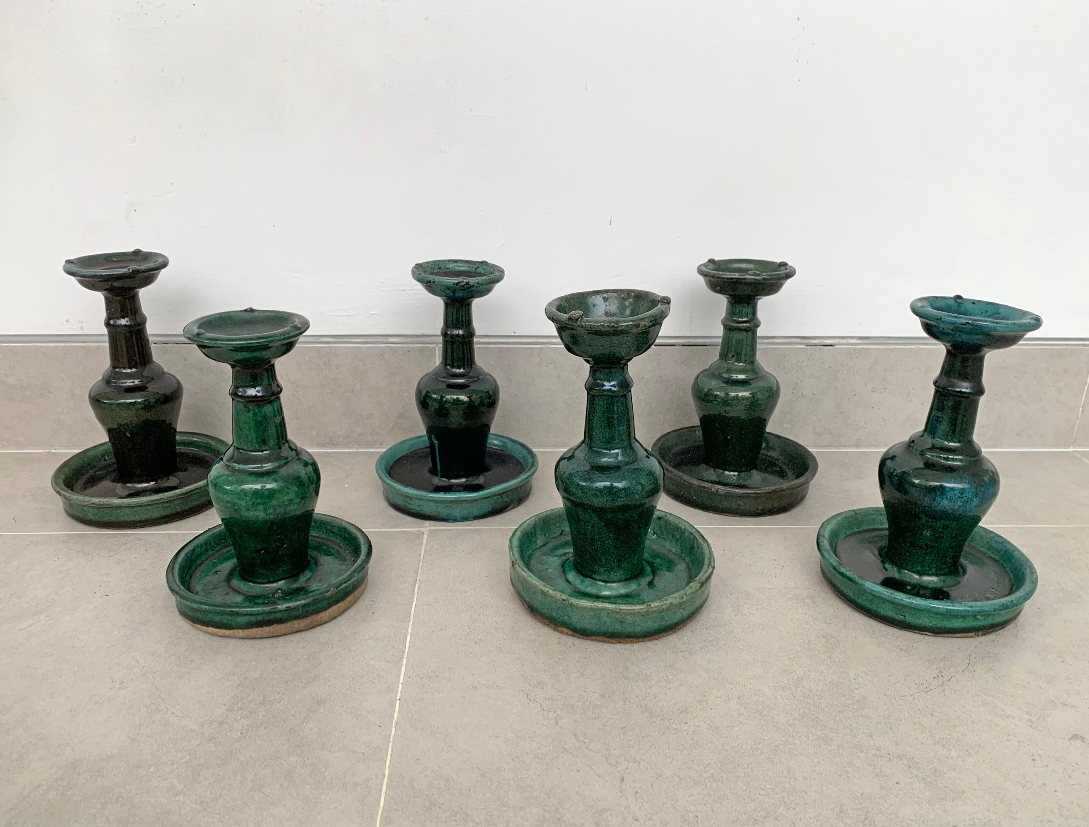 This set of 6 Shiwan ware oil lamps from the early 20th century feature the distinctive green glaze. Shiwan ware is a style of Chinese pottery from the Shiwanzhen district near Guangdong, China. 

Each oil lamp is of roughly similar dimensions;