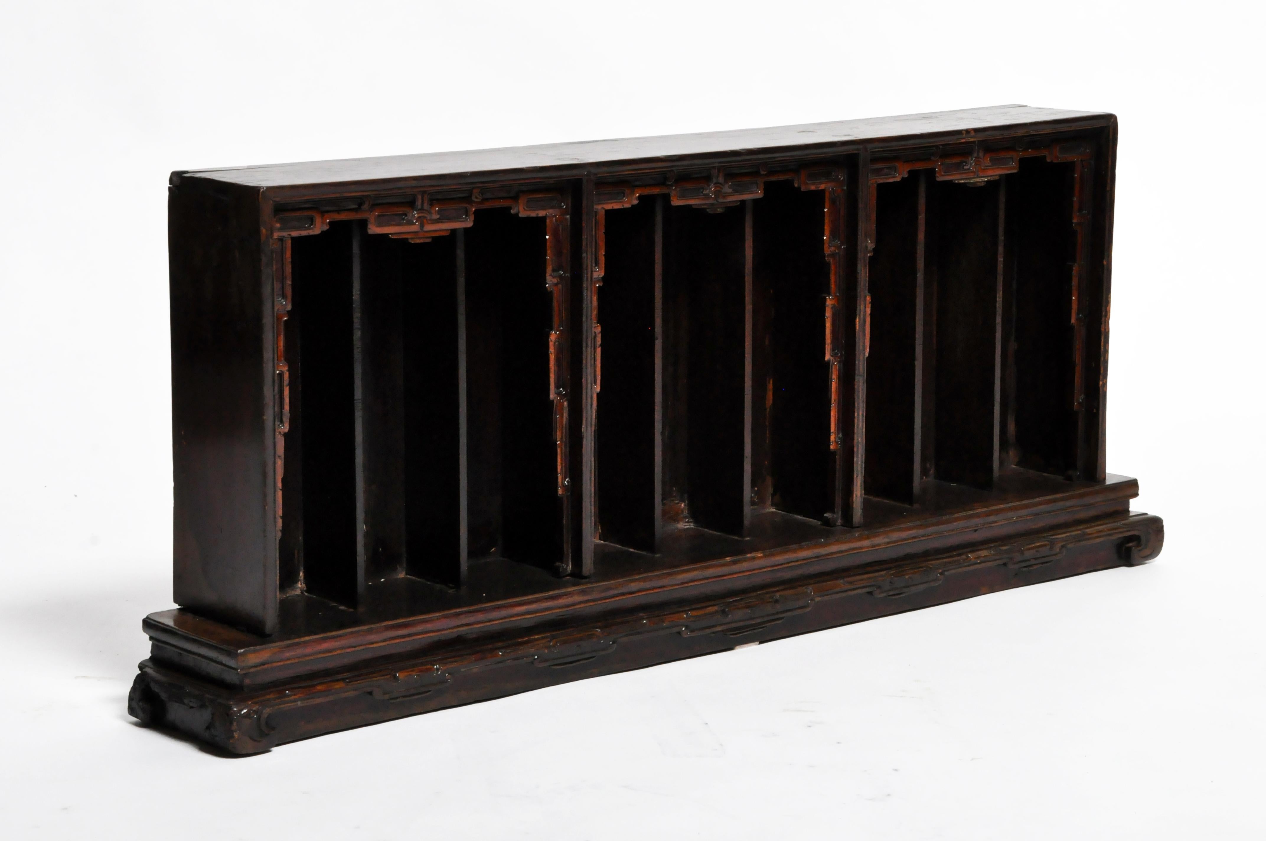 This slotted display shelf features narrow alcoves for holding ancestral figurines. It was probably part of a much more elaborate display built in tiers. The centerpiece of the display was an ancestral scroll painting. In front and below, a table